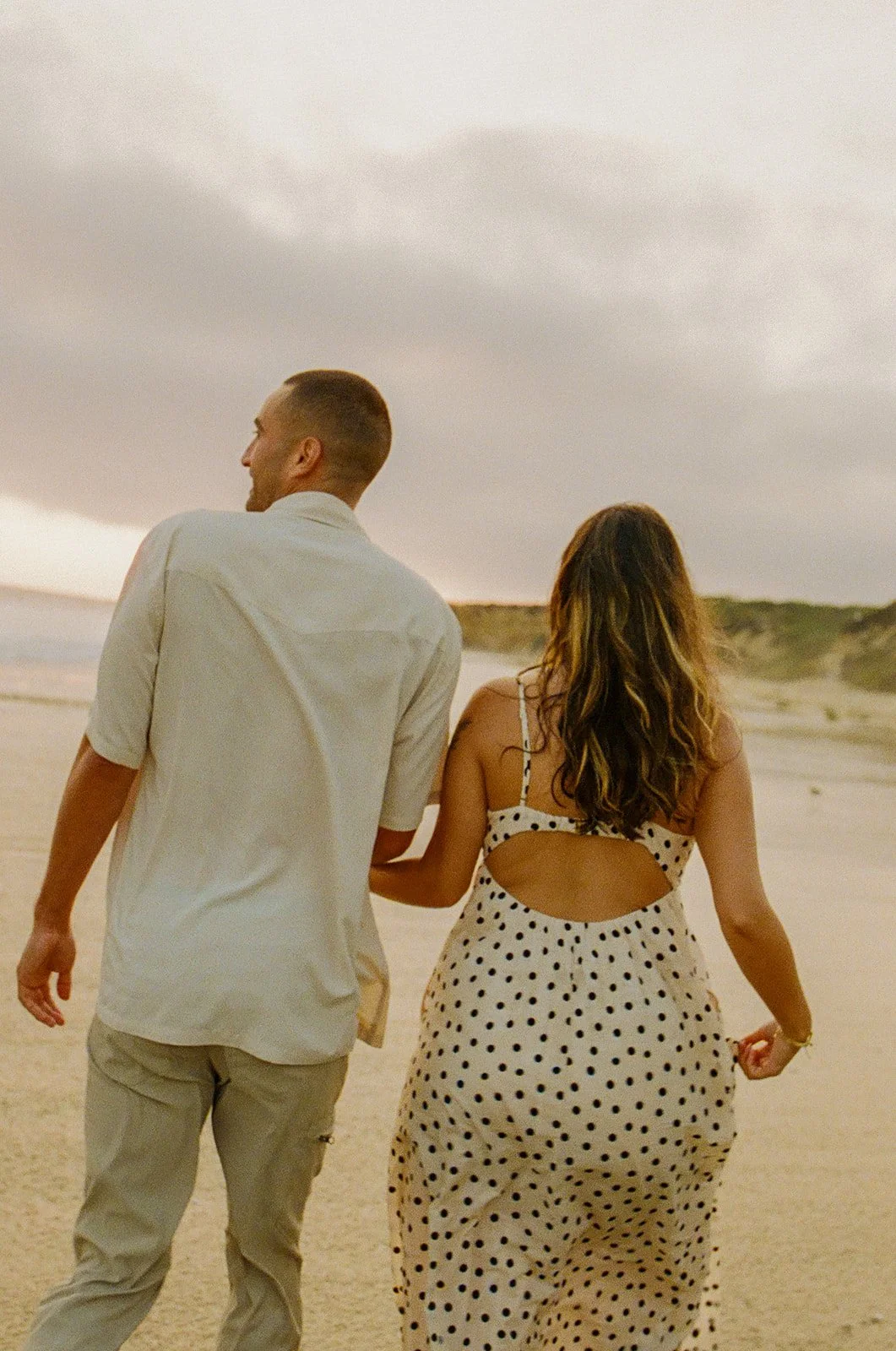 A couple in the ocean showing what to wear for engagement photosA couple on the beach showing what to wear for engagement photos