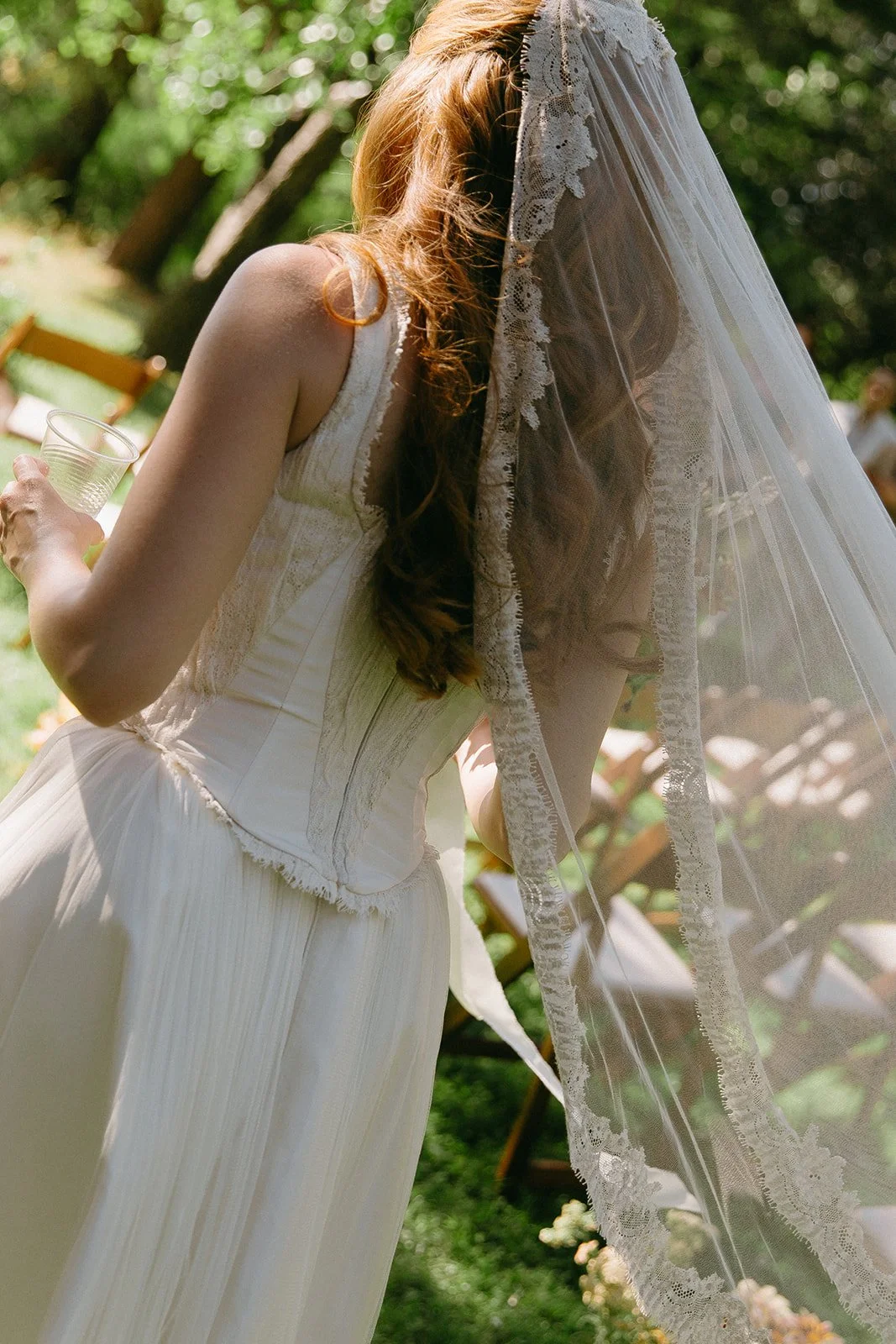 A bride posing for bridal portraits in a garden wedding dress and veil