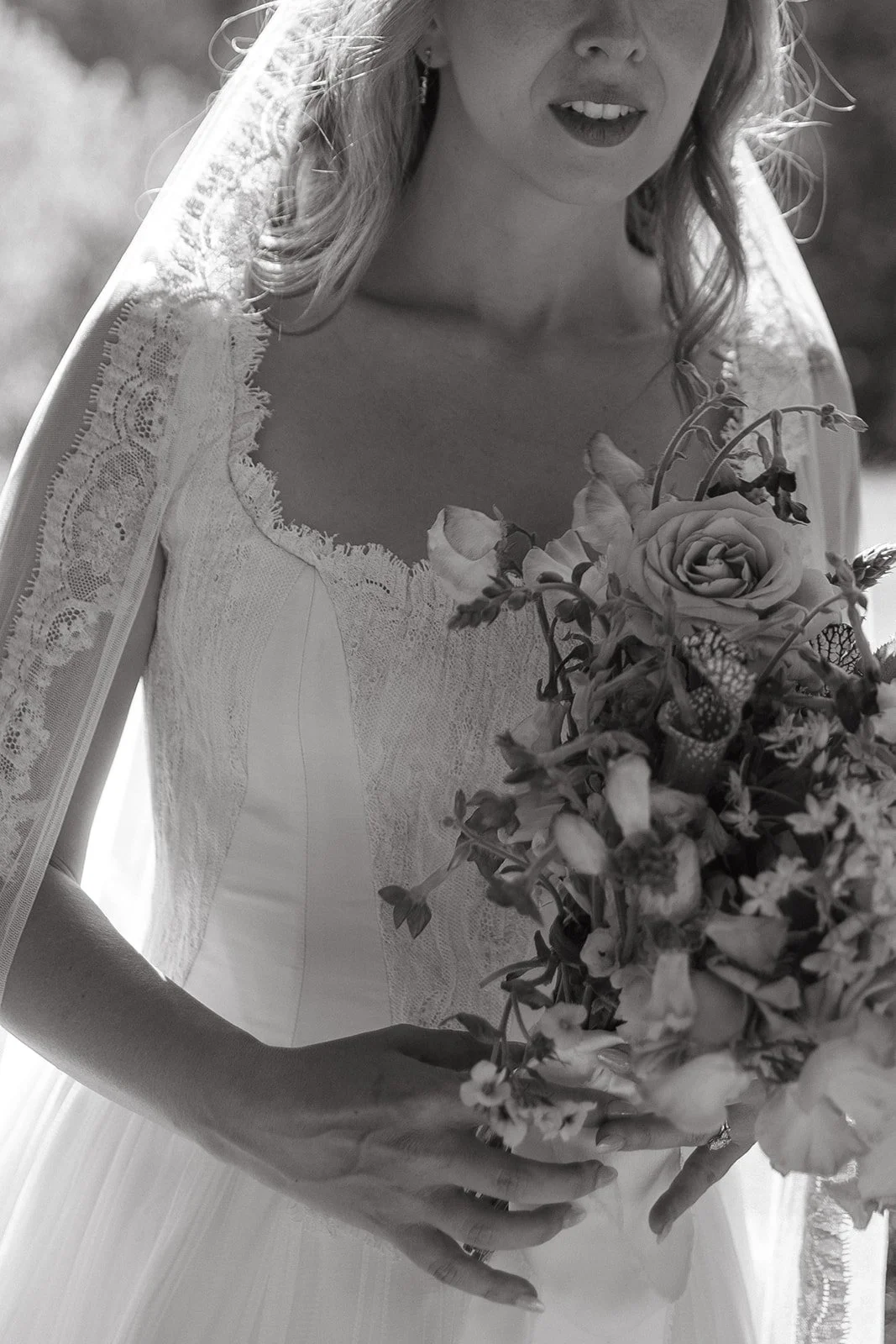 A bride posing for bridal portraits in a garden wedding dress and veil