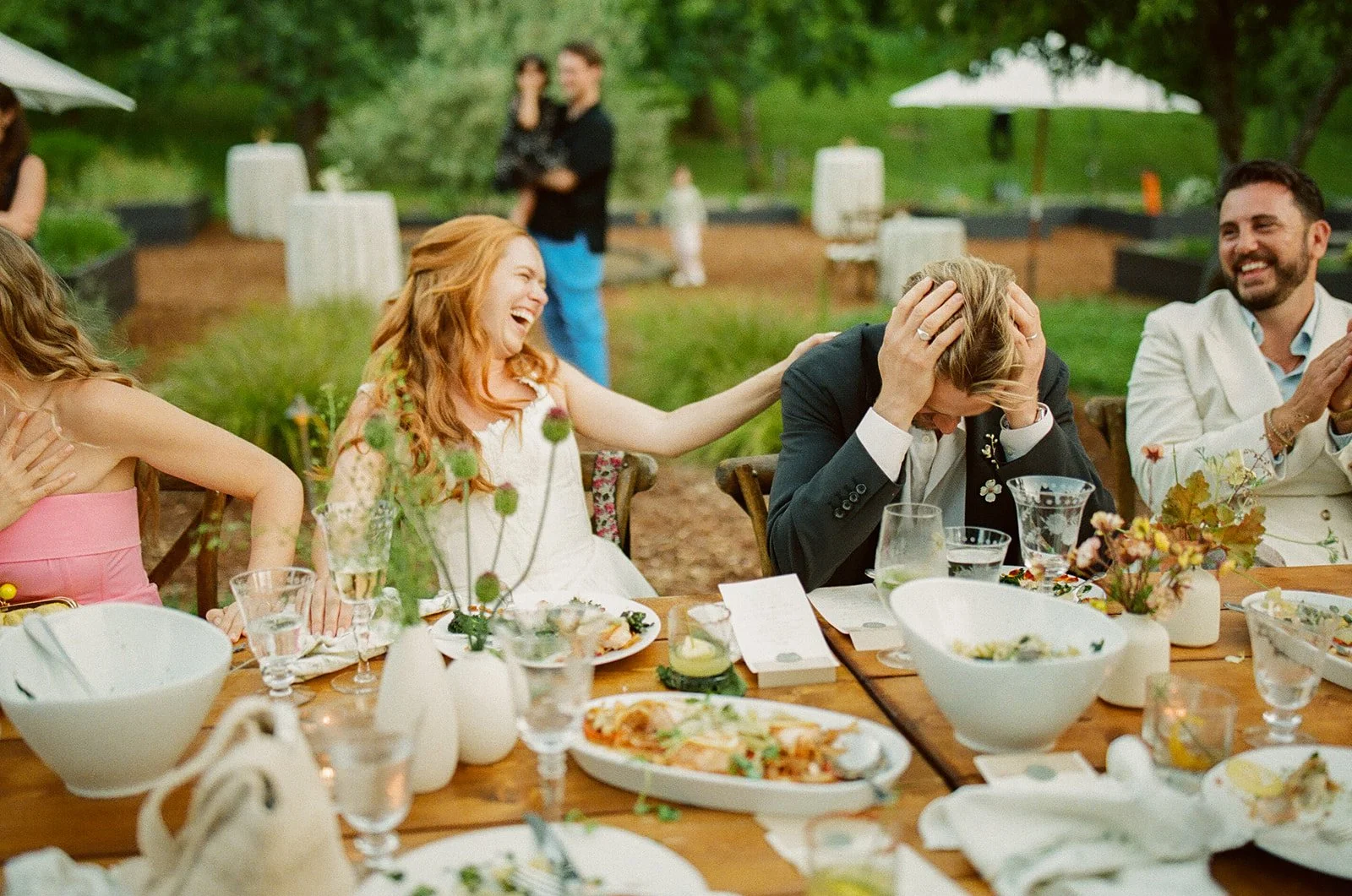 A bride and groom laughing at toasts during their wedding reception
