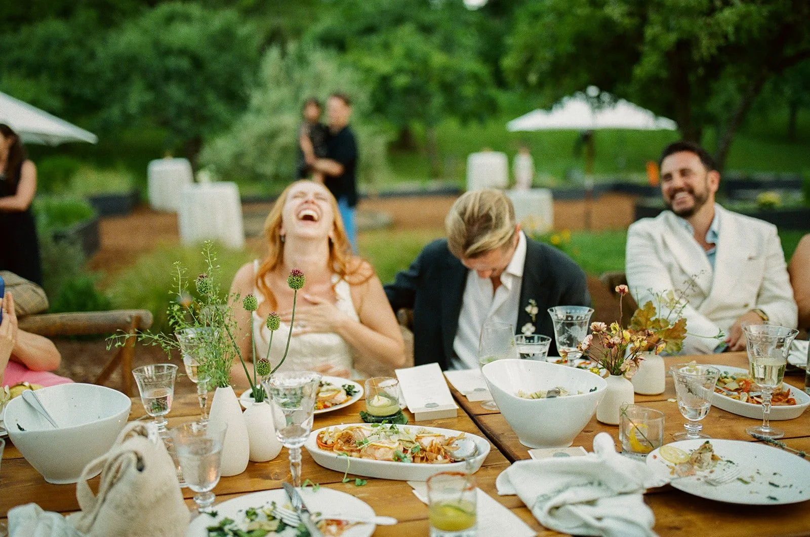 A bride and groom laughing at toasts during their wedding reception