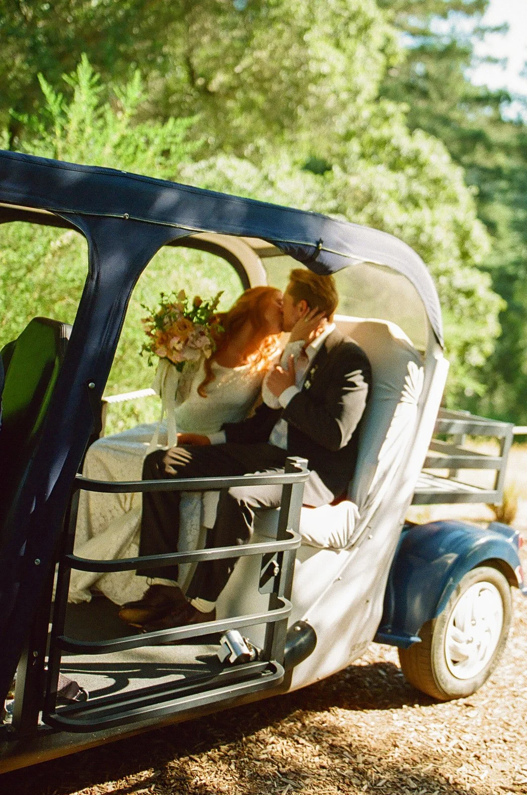 A bride and groom in their wedding getaway car