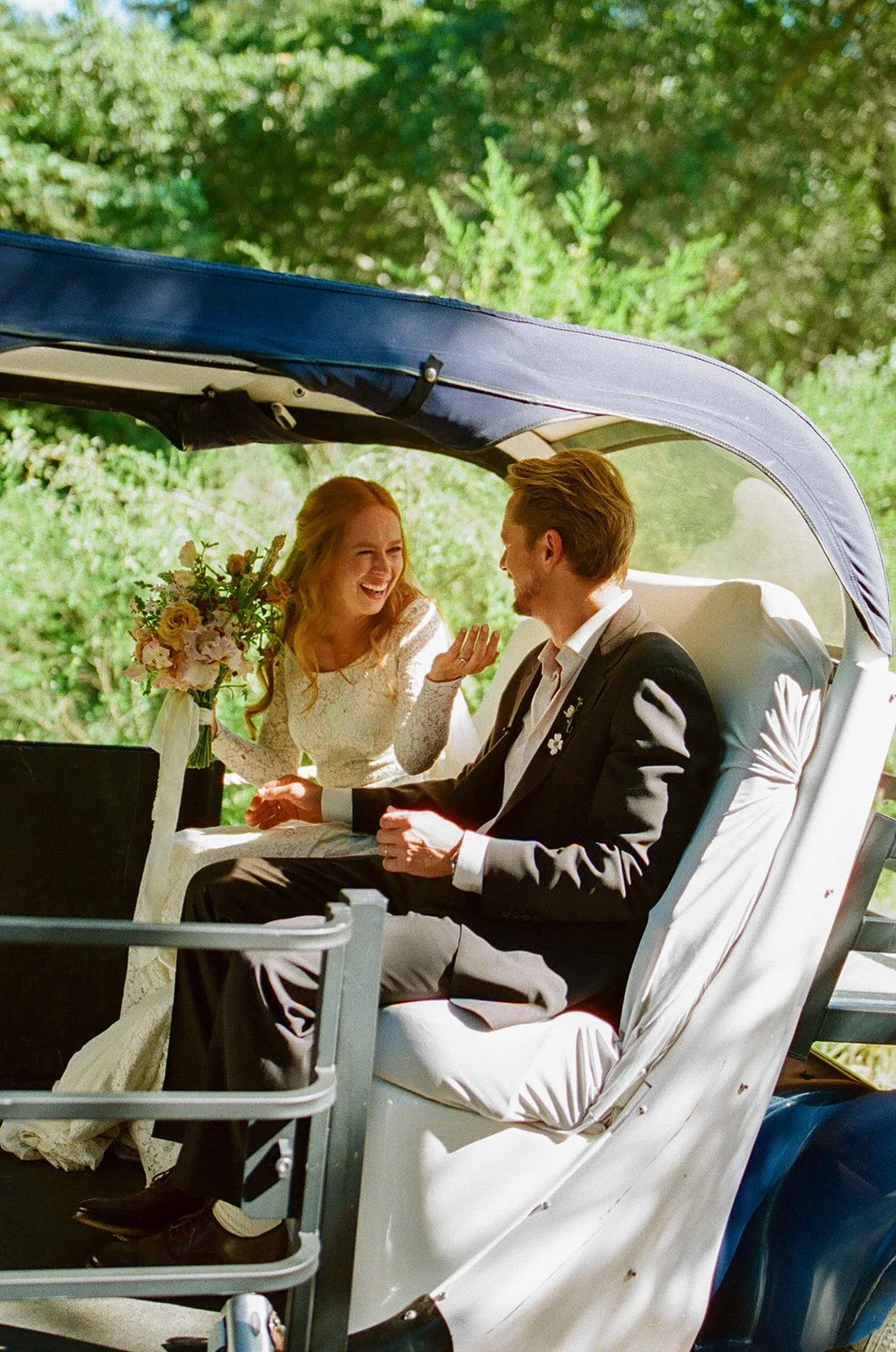 A bride and groom in their wedding getaway car