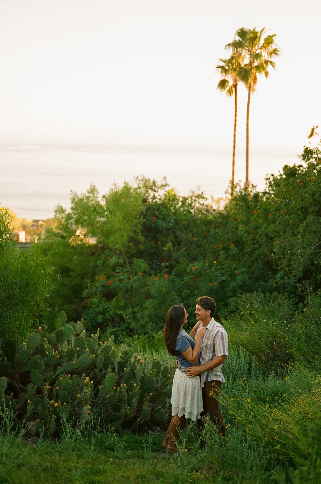 A couple posing for film engagement photos at Laguna Beach