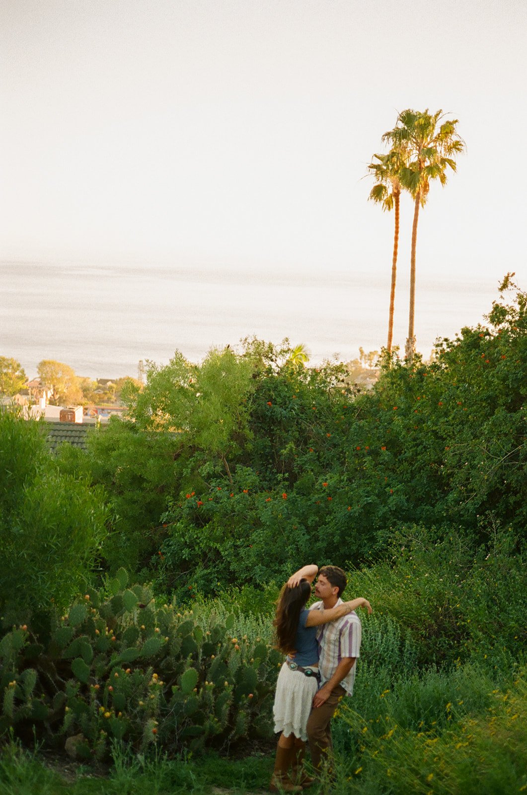 A couple posing for film engagement photos at Laguna Beach