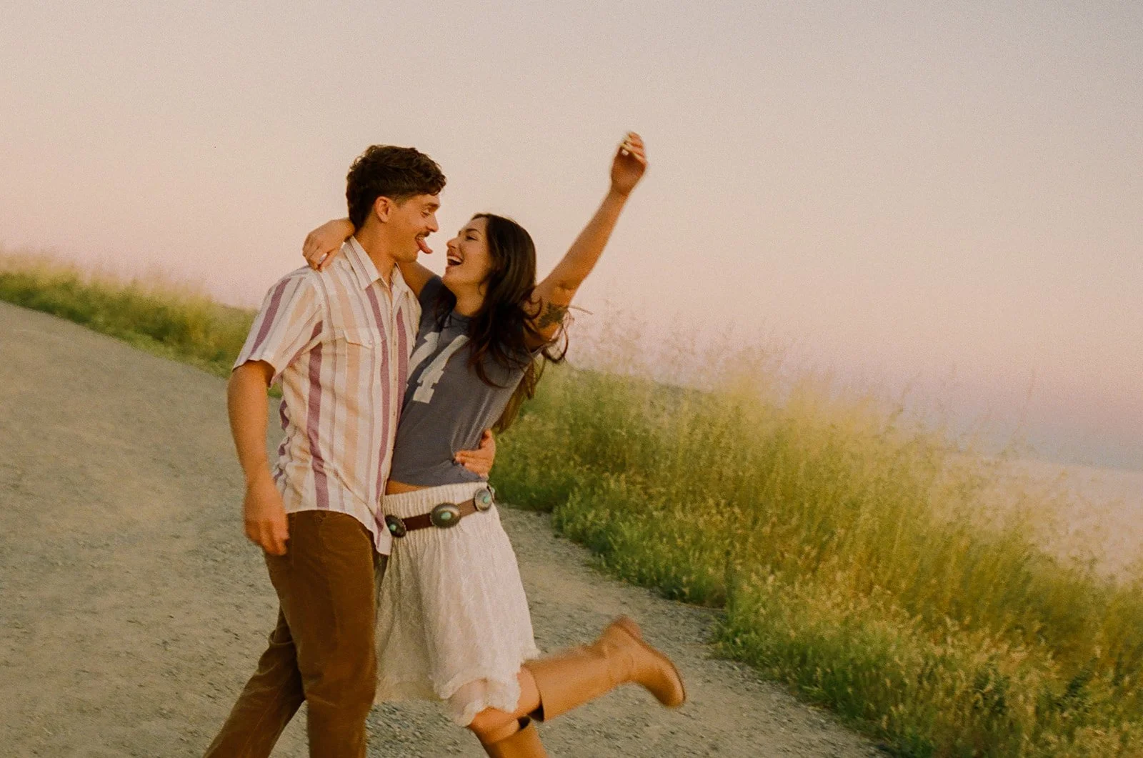 A couple dancing on a dirt road for film engagement photos