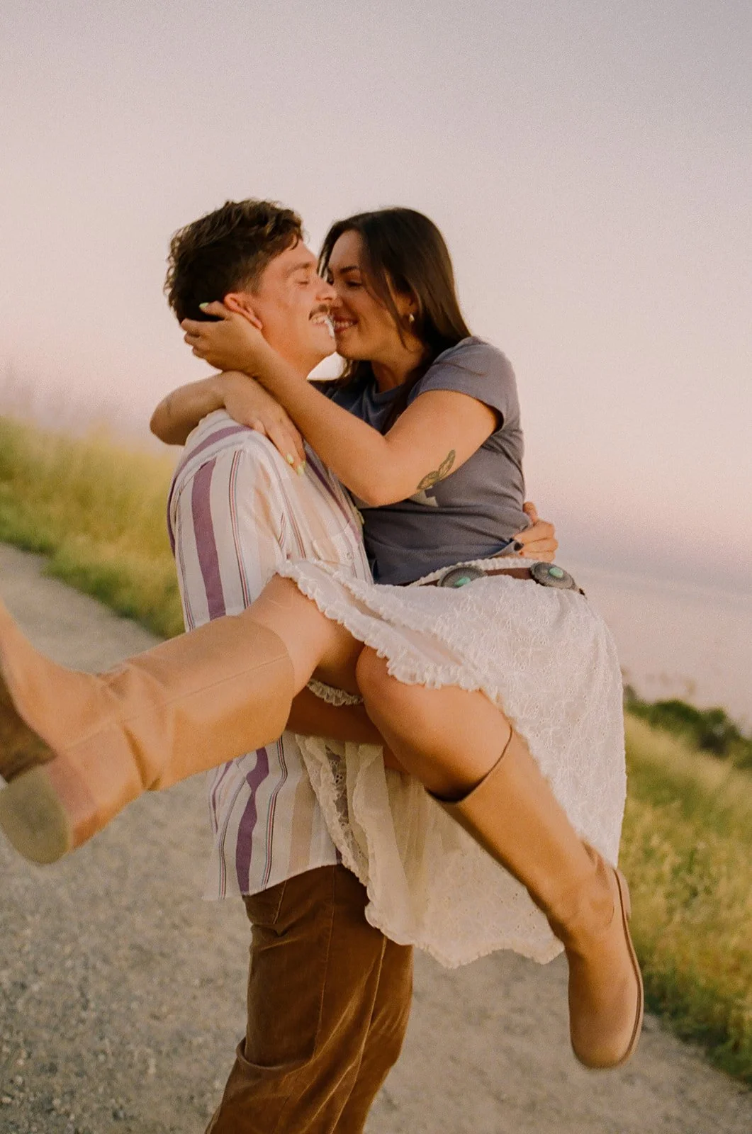 A couple laughing in film engagement photos at Laguna Beach
