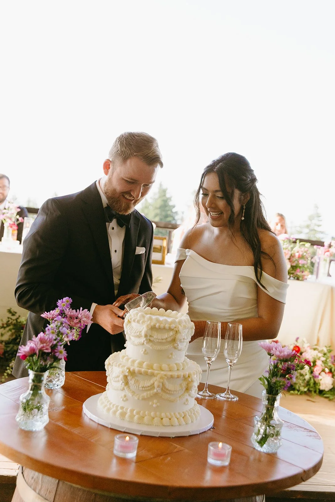 A bride and groom cutting a cake honoring wedding traditions
