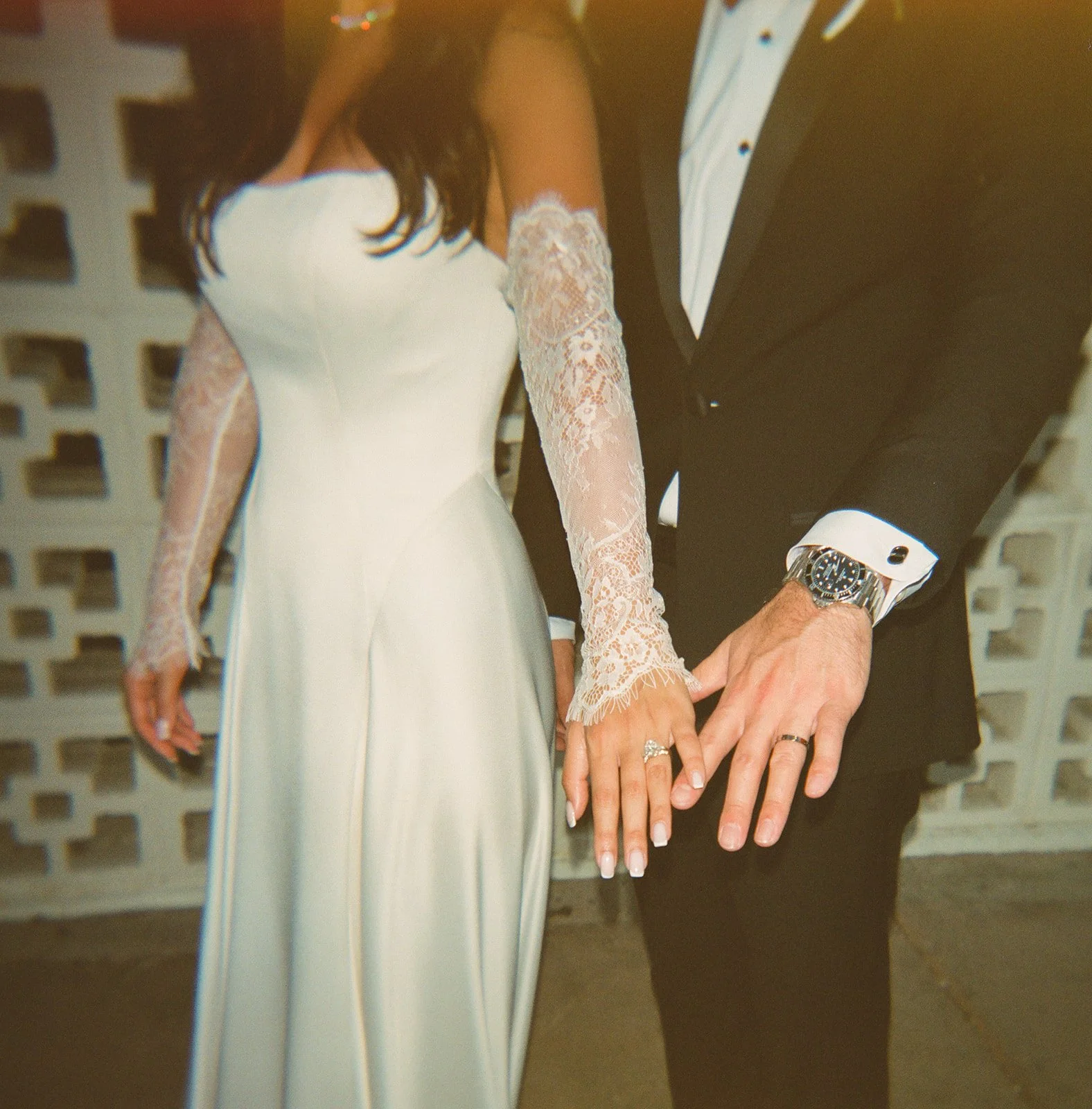 A bride and groom showing off their wedding bands