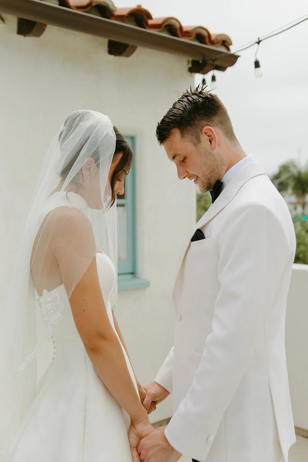 A bride and groom posing for first look wedding portraits at a san clemente wedding