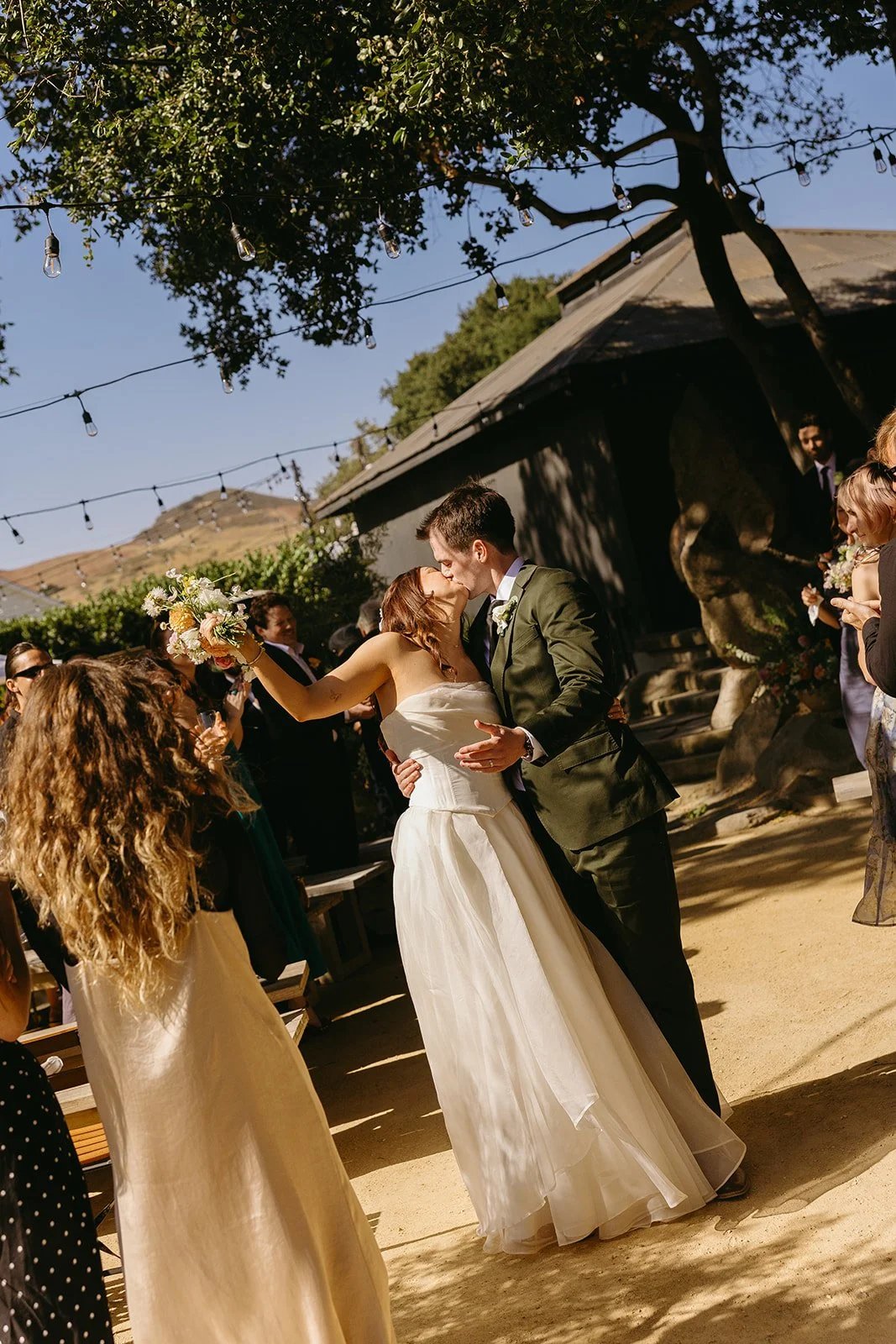A bride and groom kissing after their wedding ceremony