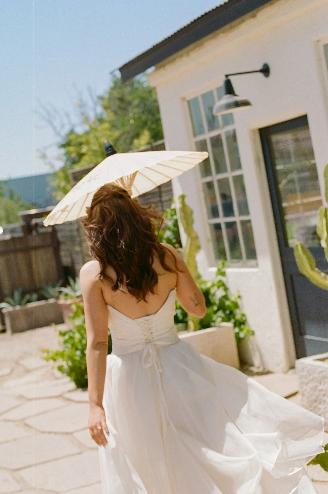 A bride walking to her small wedding with a parasol
