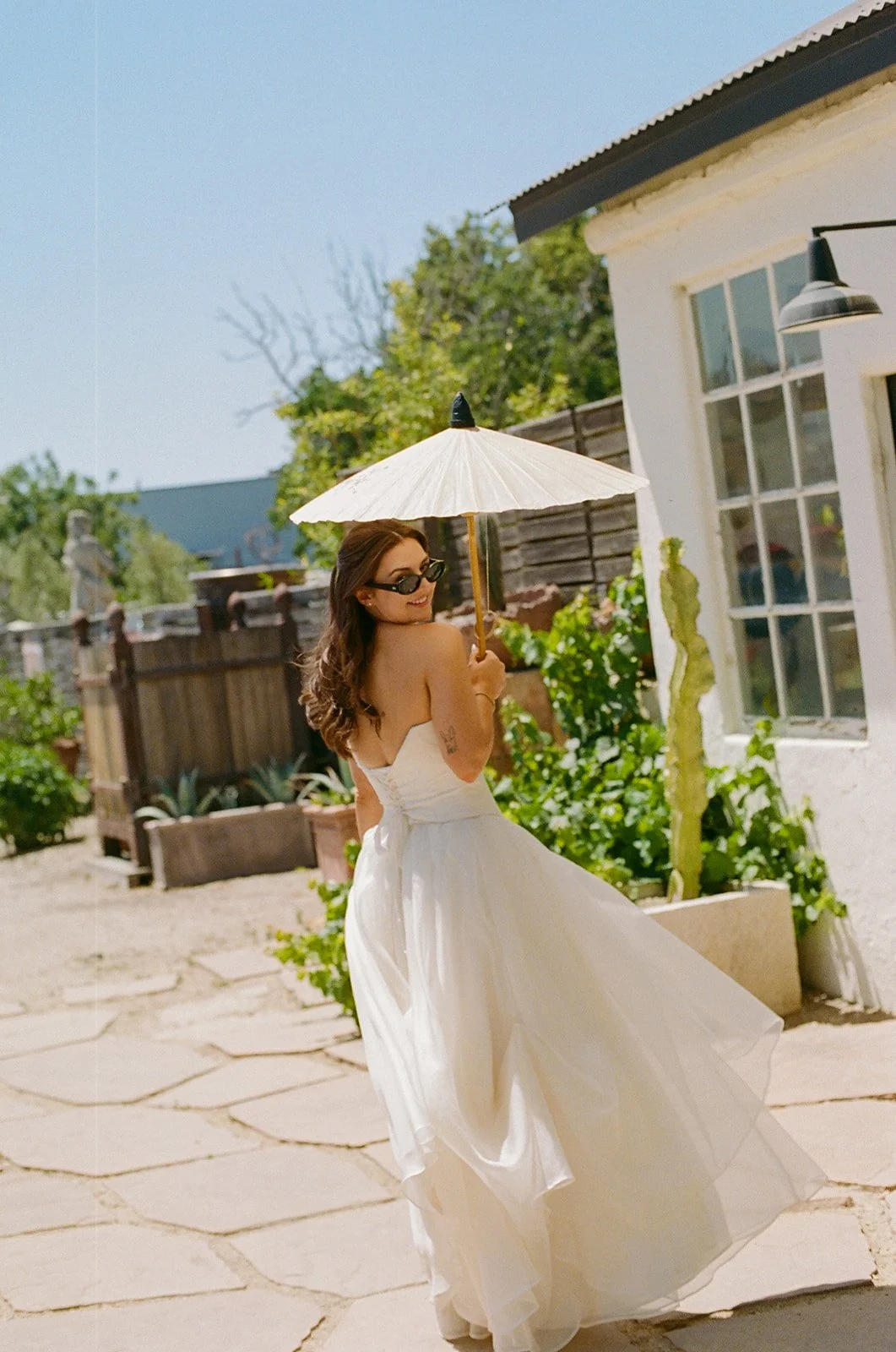 A bride walking to her small wedding with a parasol