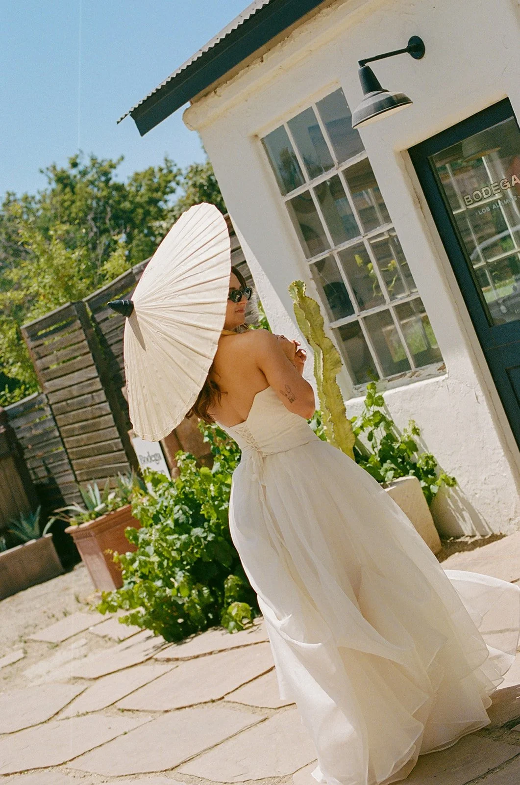 A bride walking to her small wedding with a parasol