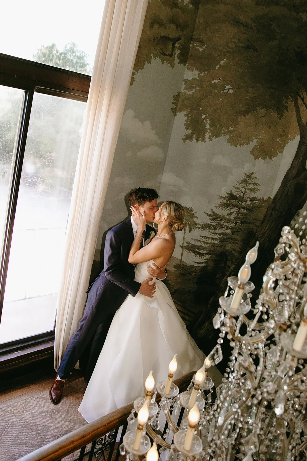 A bride and groom kissing inside of their estate wedding venue