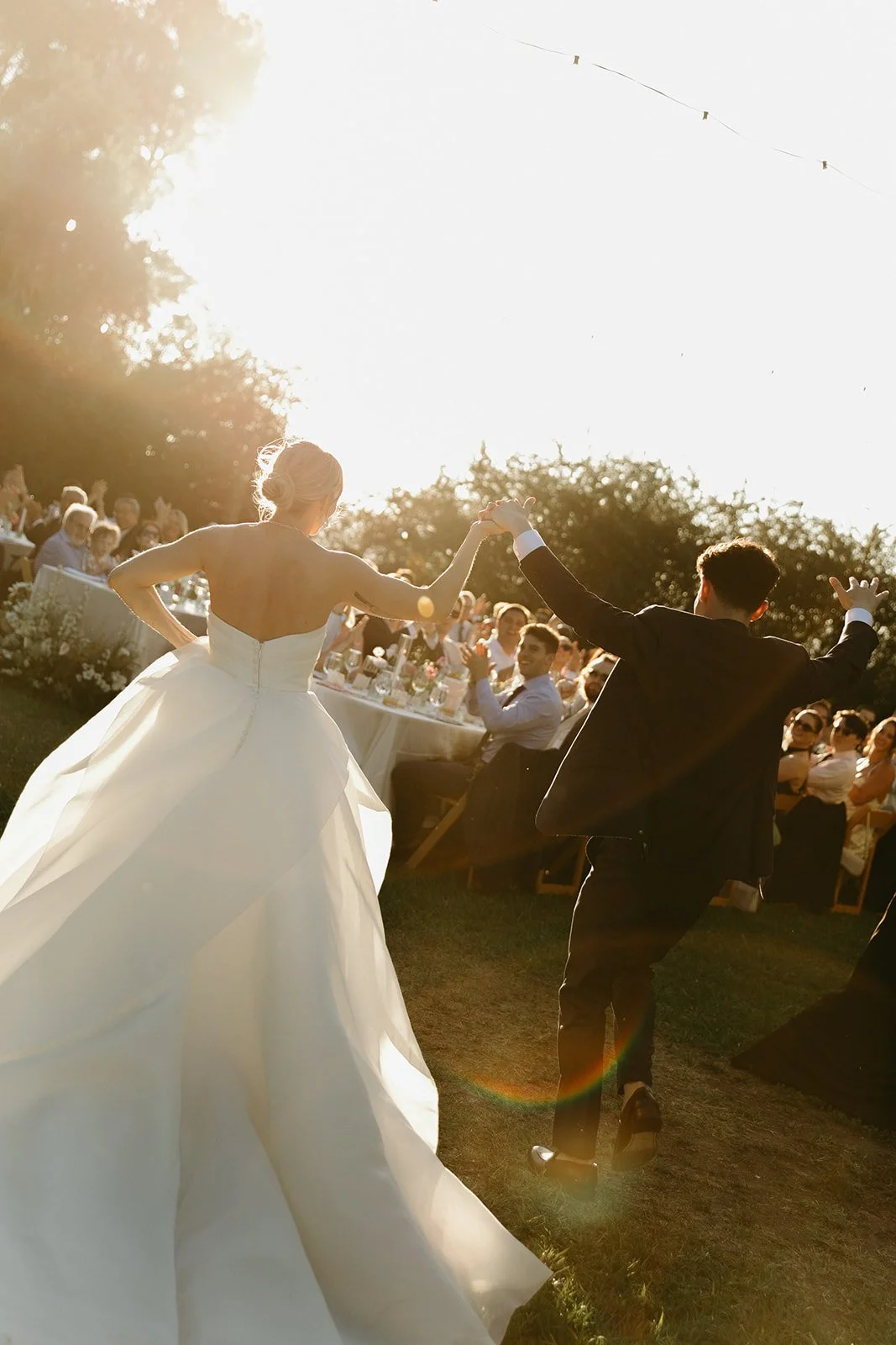A bride and groom running into their wedding reception
