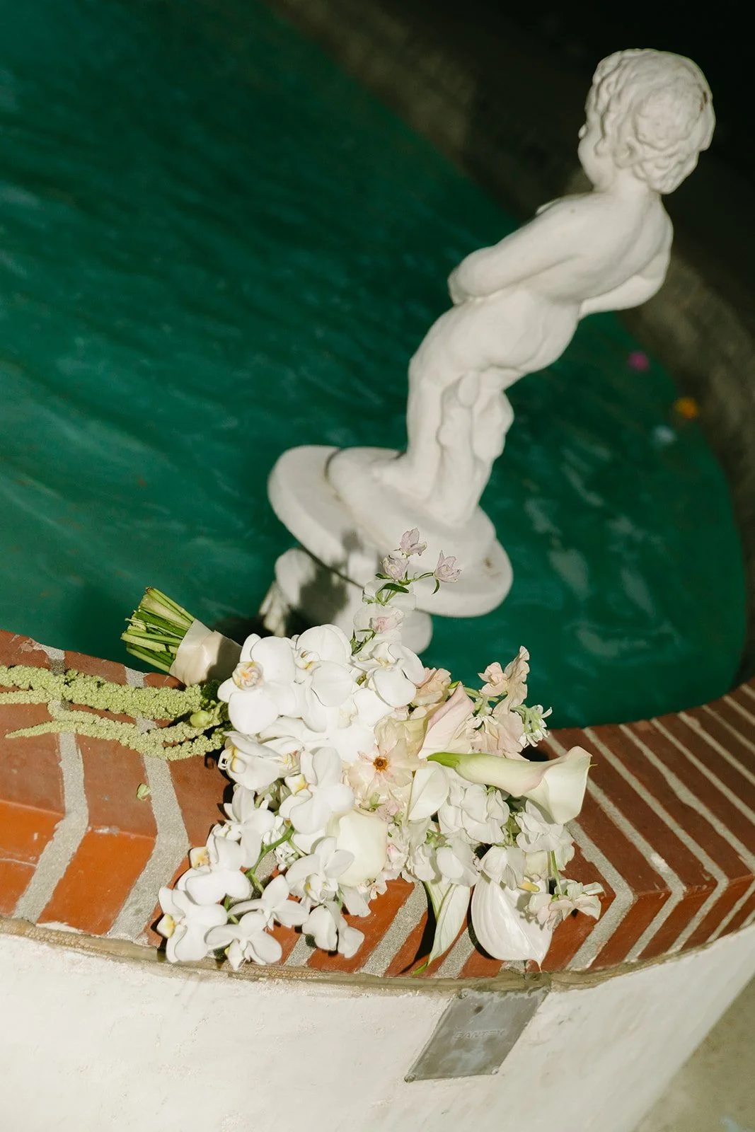 A wedding bouquet lying on a fountain