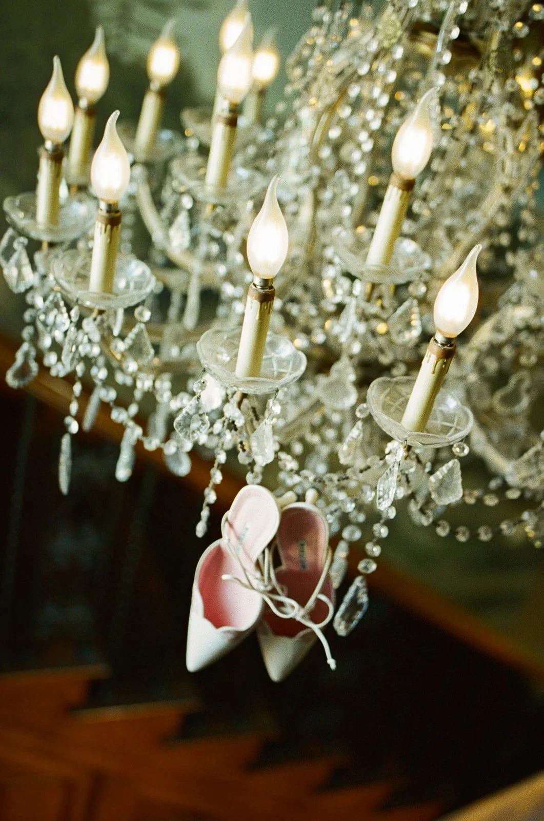 A pair of wedding shoes hanging from a chandelier at an estate wedding venue