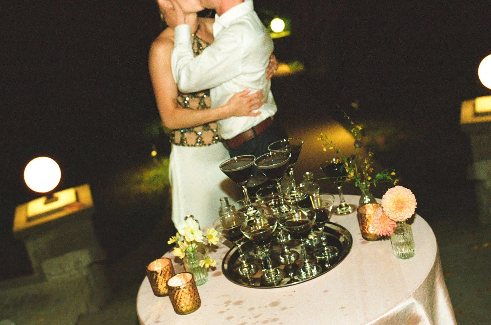A bride and groom kissing at a martini tower