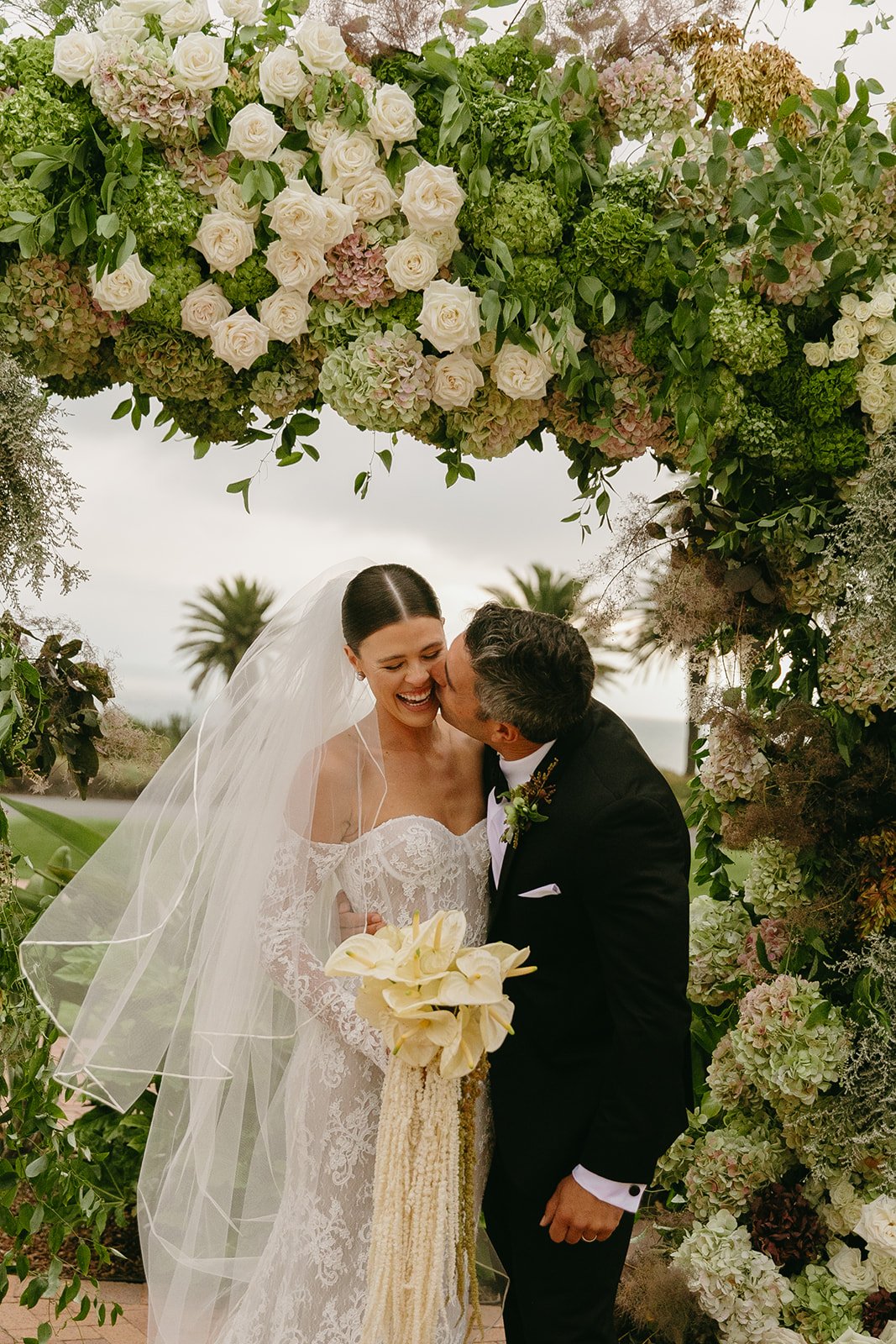 A bride and groom kissing at the ceremony site at Terranea Resort