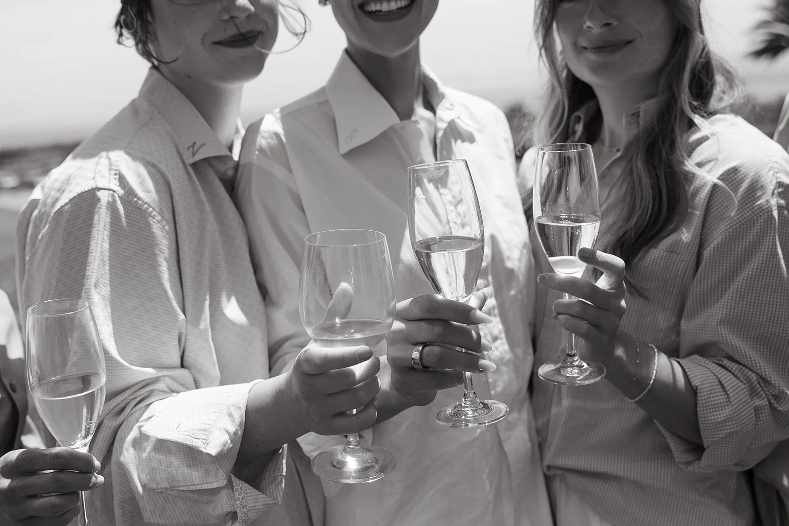 A bride and bridesmaids holding glasses while getting ready