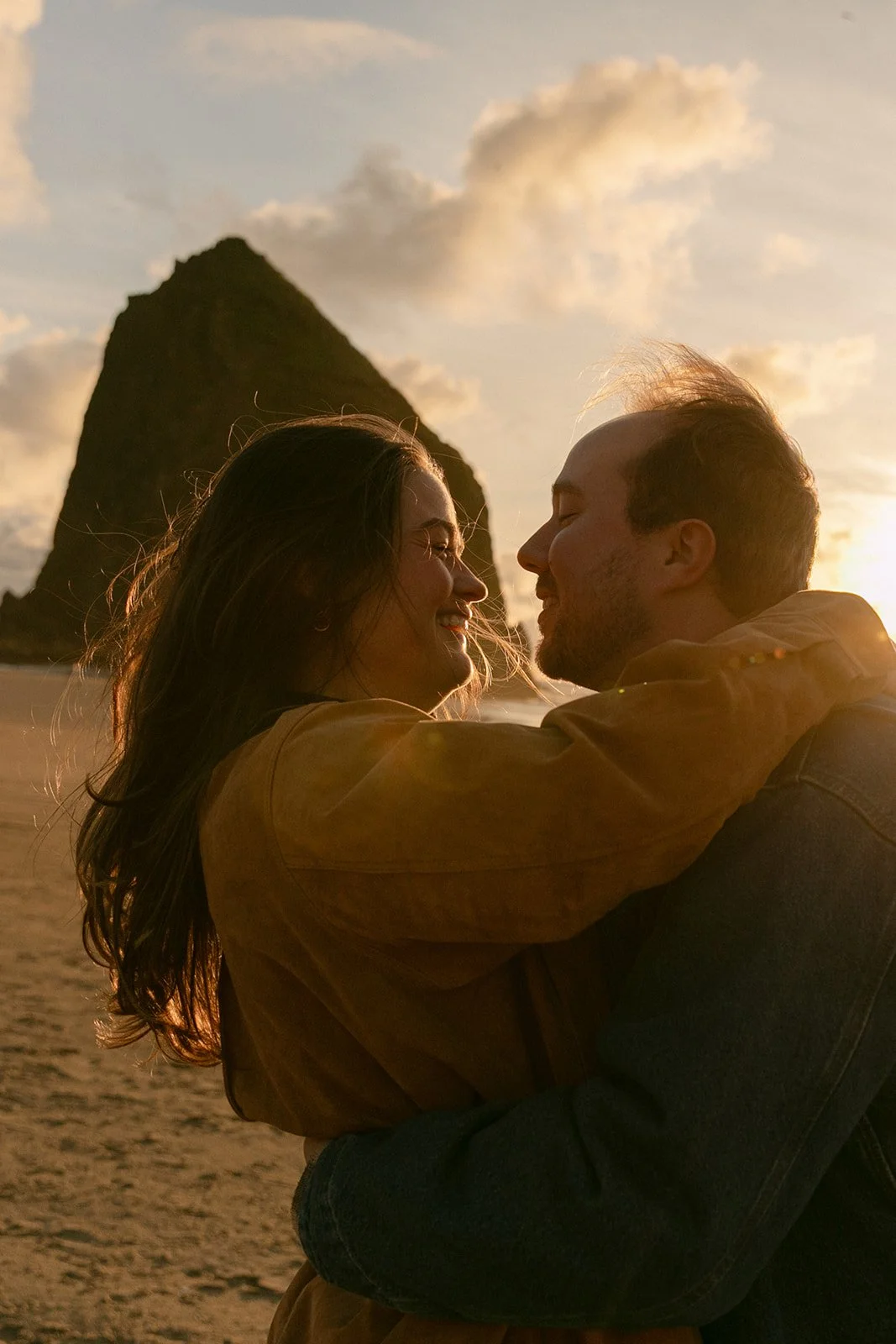 A couple taking engagement romantic engagement photos at Cannon Beach