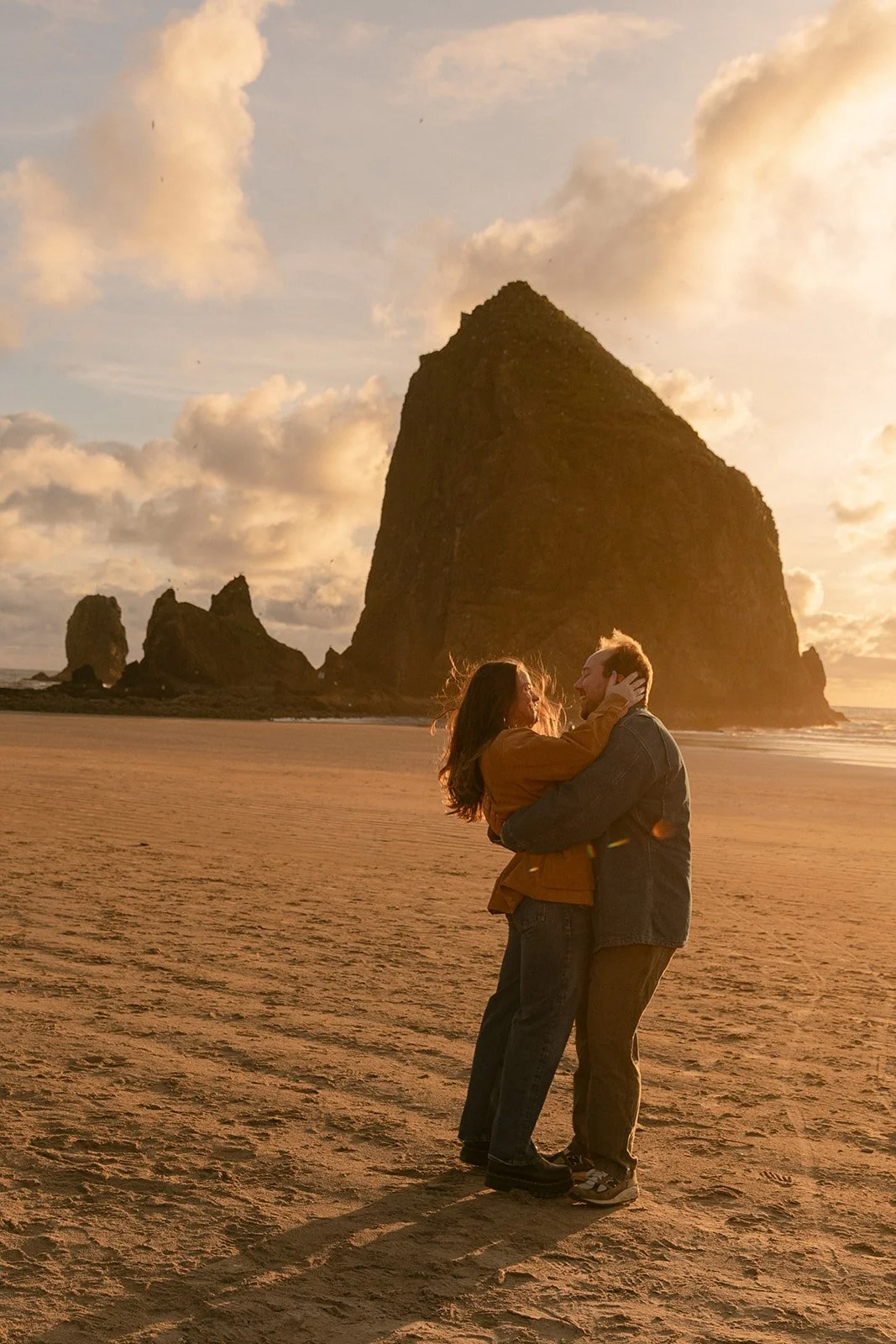 A couple taking engagement romantic engagement photos at Cannon Beach