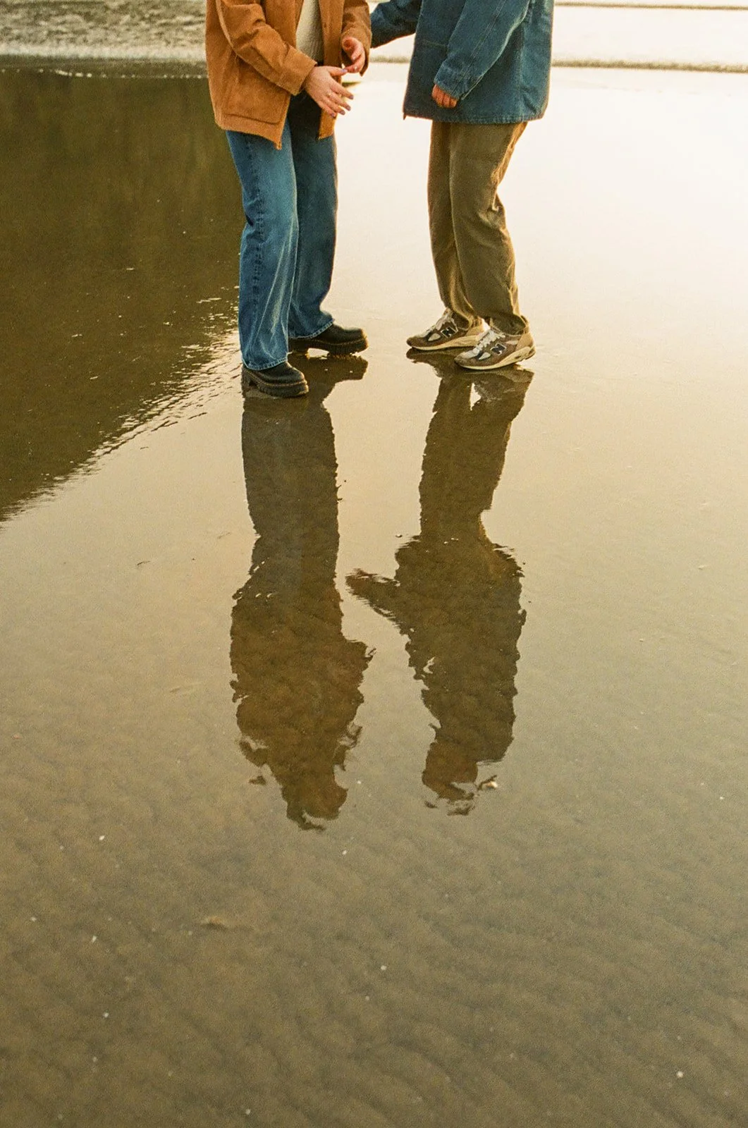 A couple taking beach engagement photos at Cannon Beach