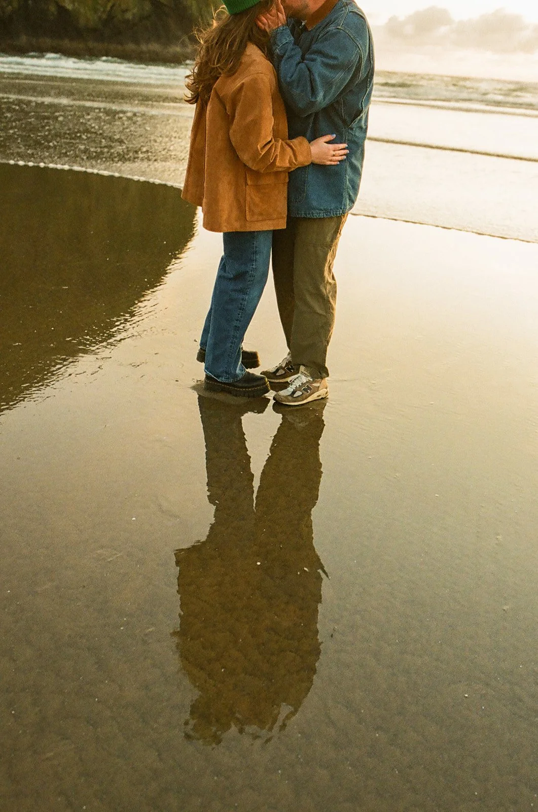 A couple taking beach engagement photos at Cannon Beach