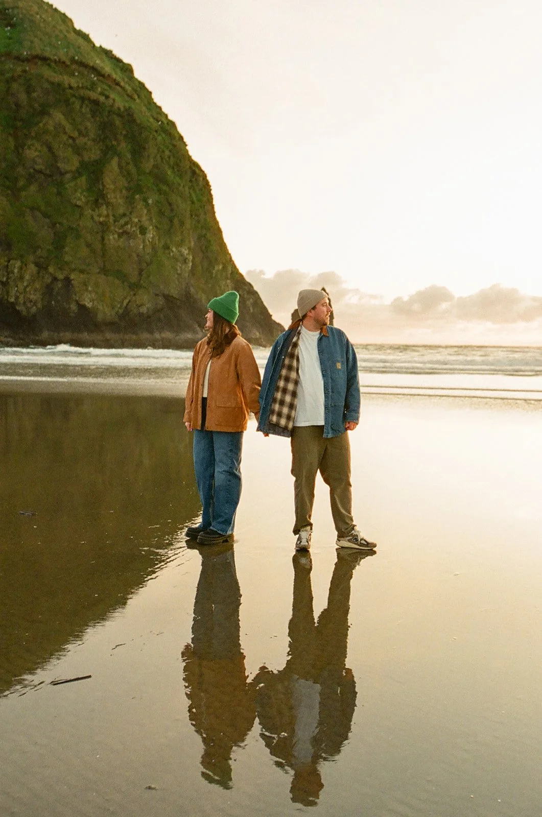 A couple taking beach engagement photos at Cannon Beach