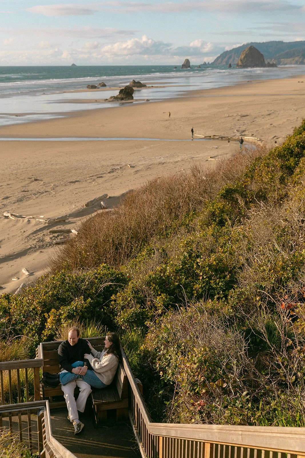 A couple taking outdoor engagement photos at Cannon Beach
