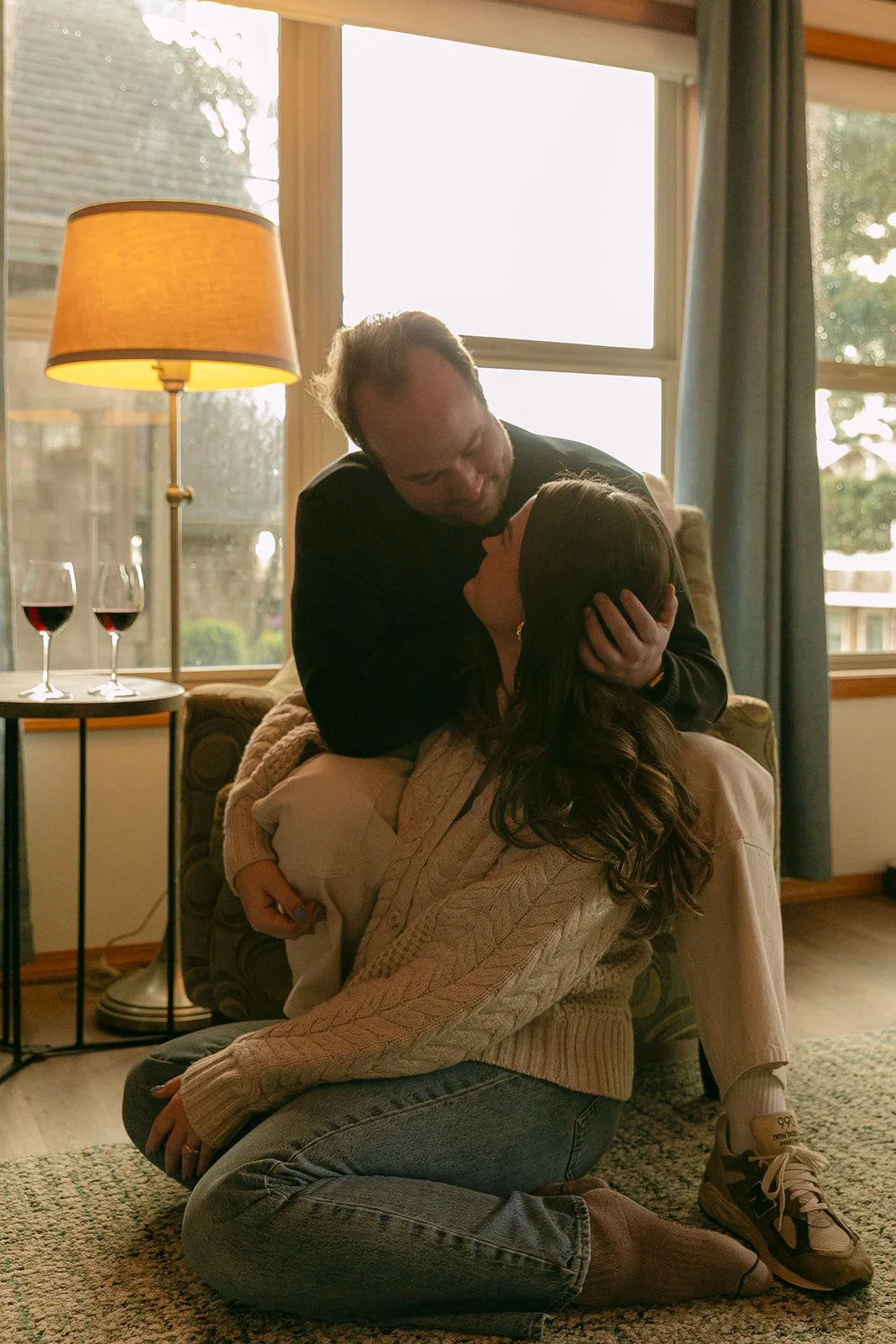 A couple taking indoor engagement photos in a family home after choosing where to take engagement photos
