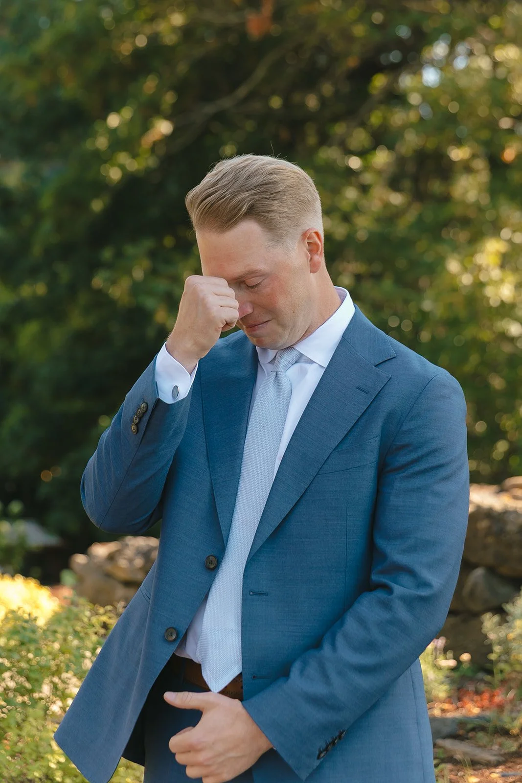 A groom crying while his bride walks down the aisle