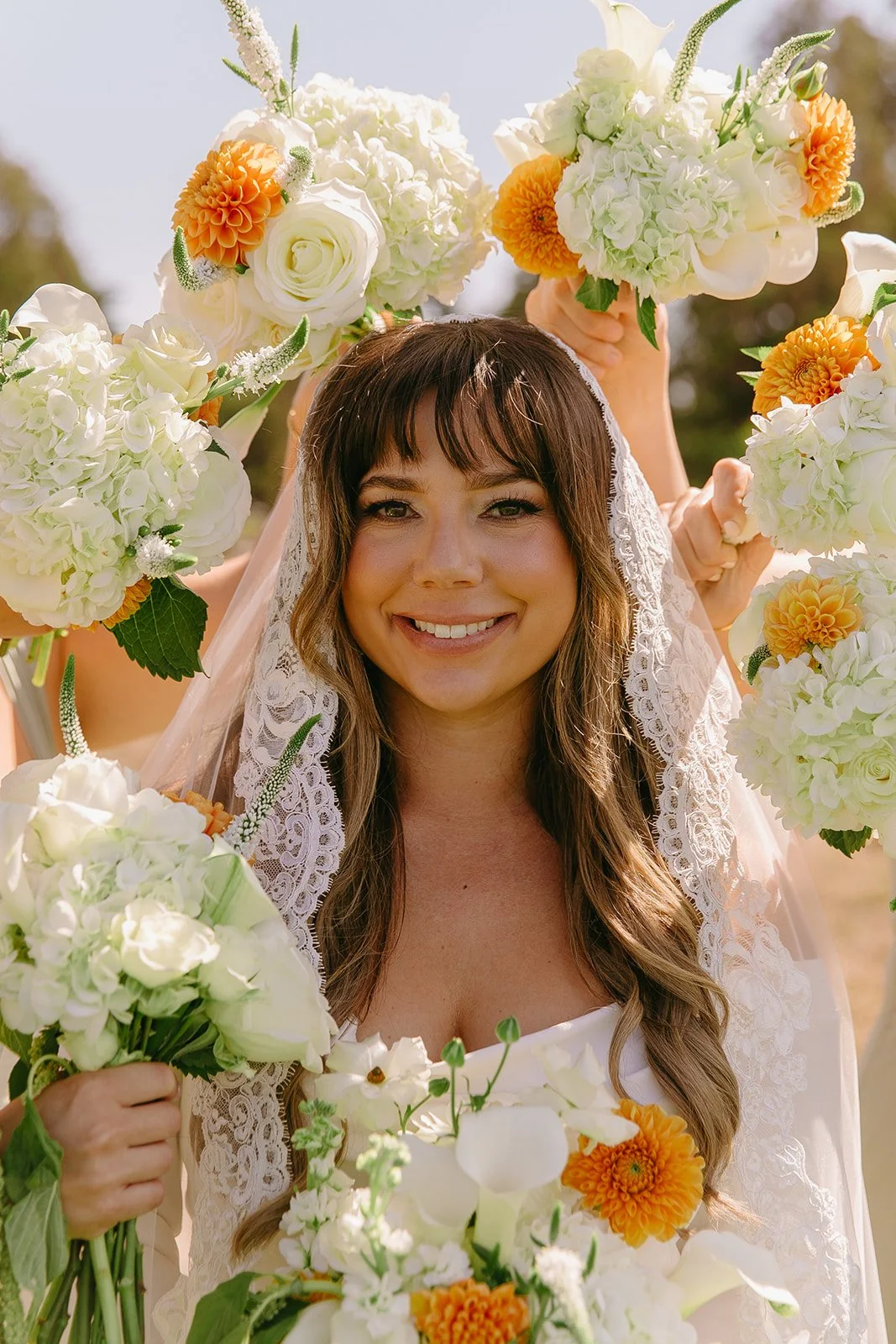 A photo of a bride surrounded by bridesmaid bouquets