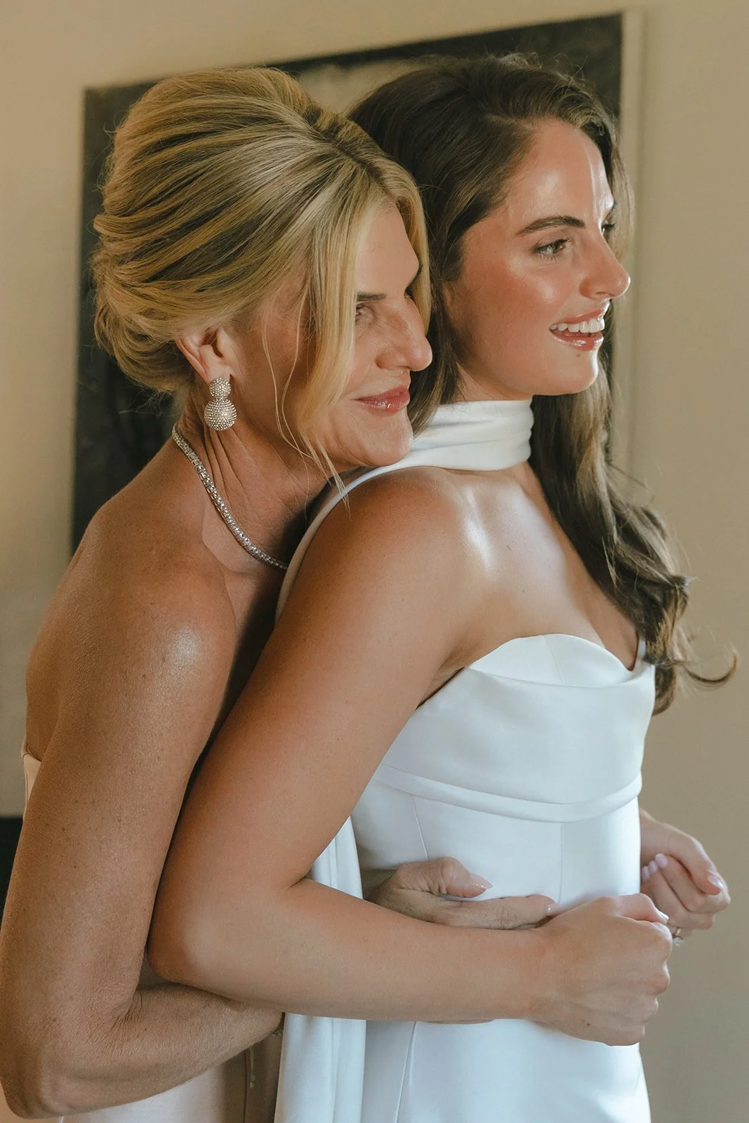A bride's mom helping her get ready for her wedding