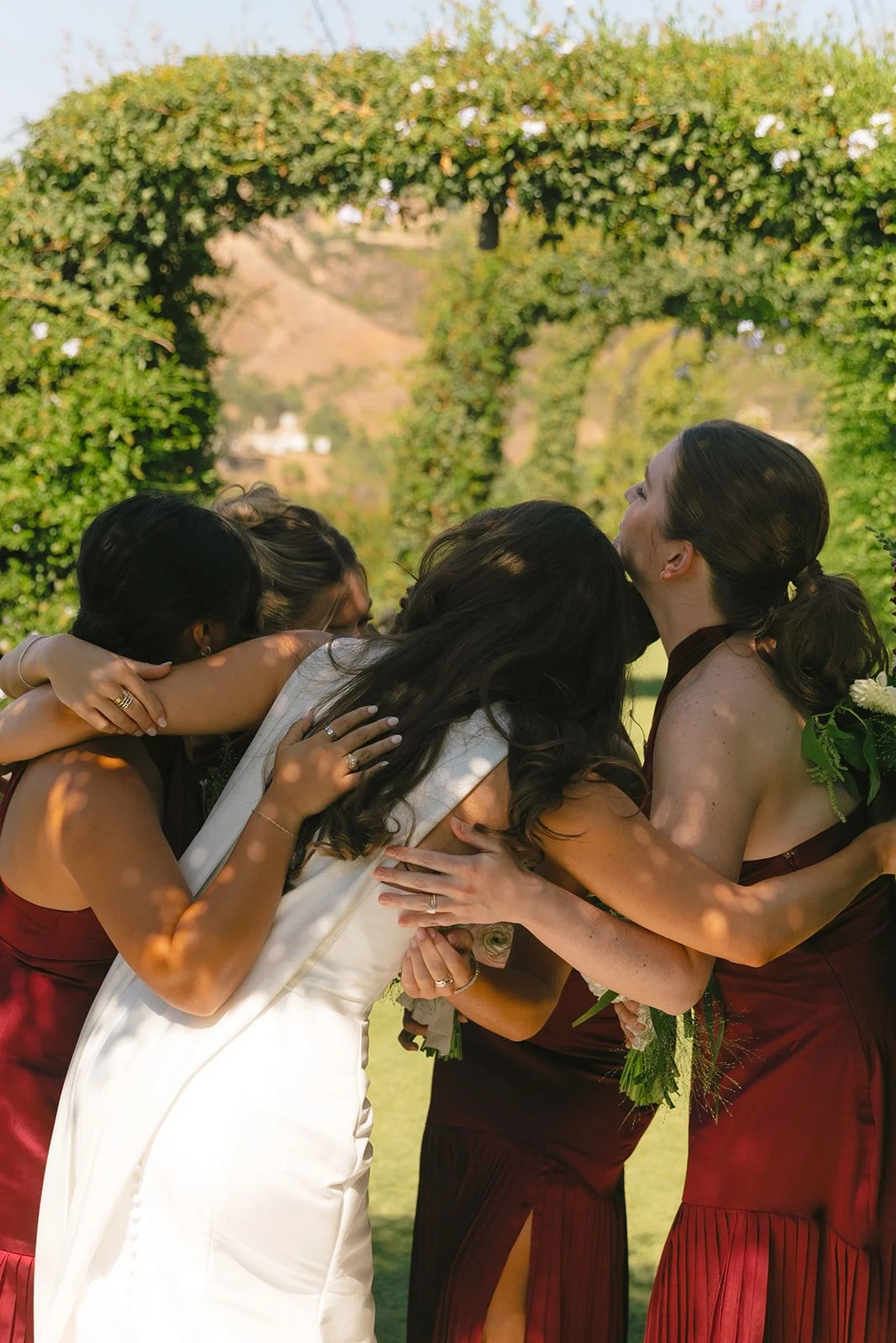 A bride hugging her bridesmaids