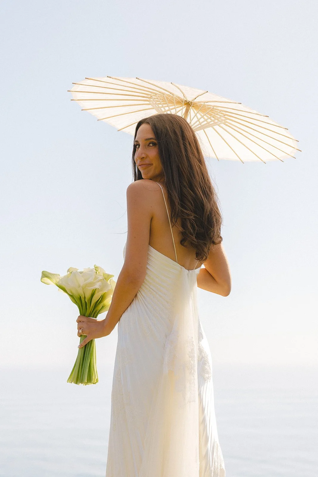 A birde holding a parasol and bouquet