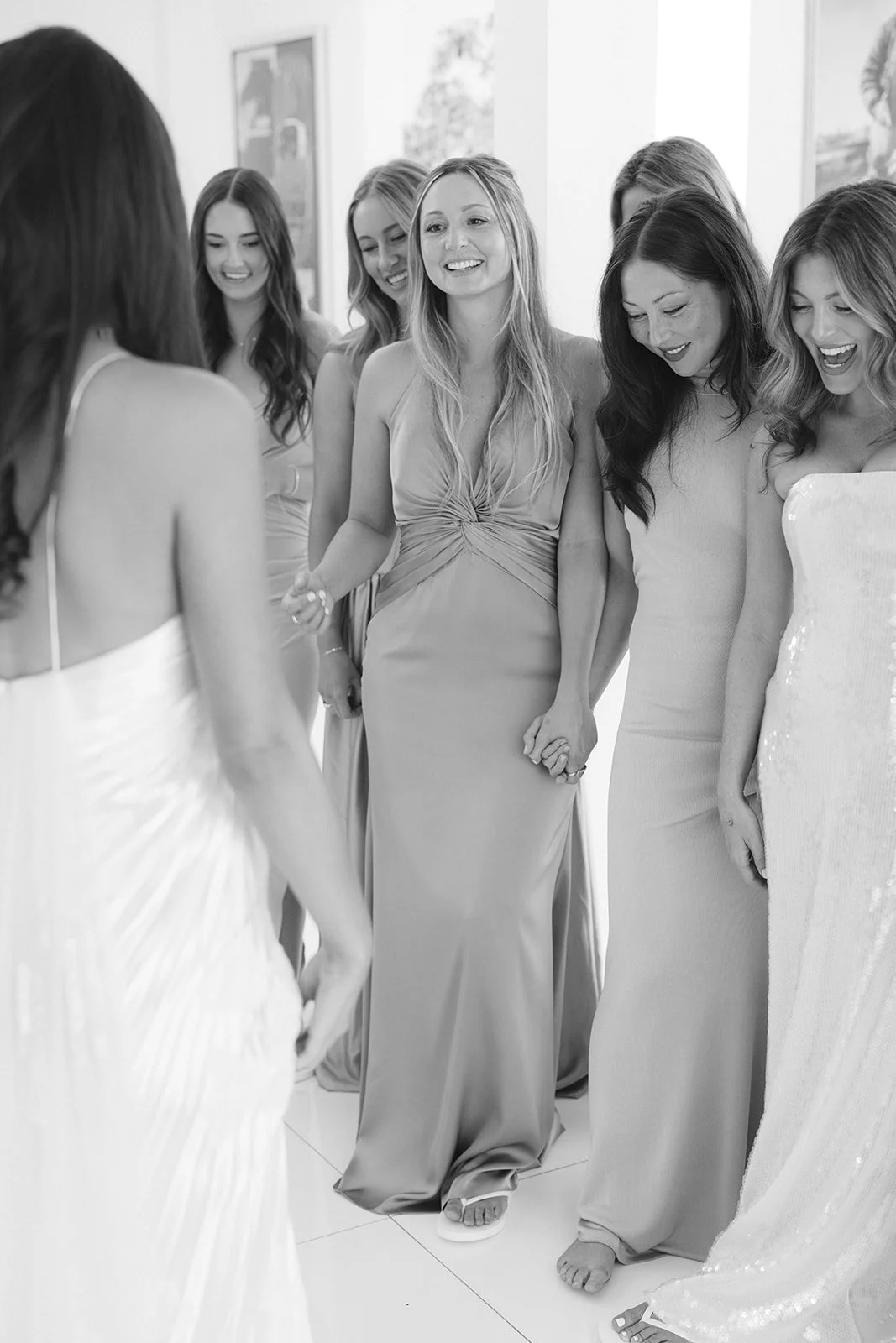 Bridesmaids reacting to a bride's wedding dress