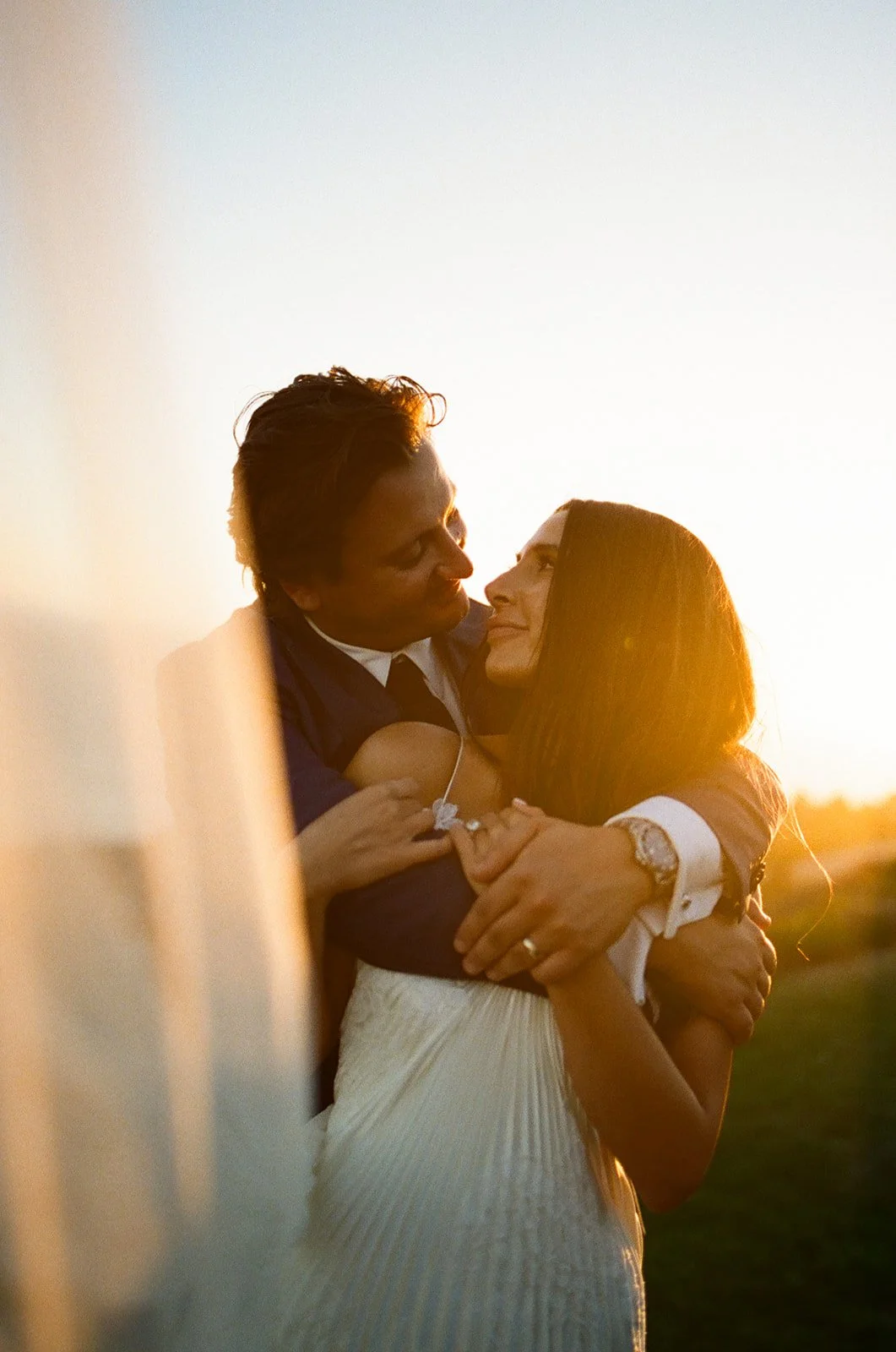 A bride and groom posing for sunset wedding photos