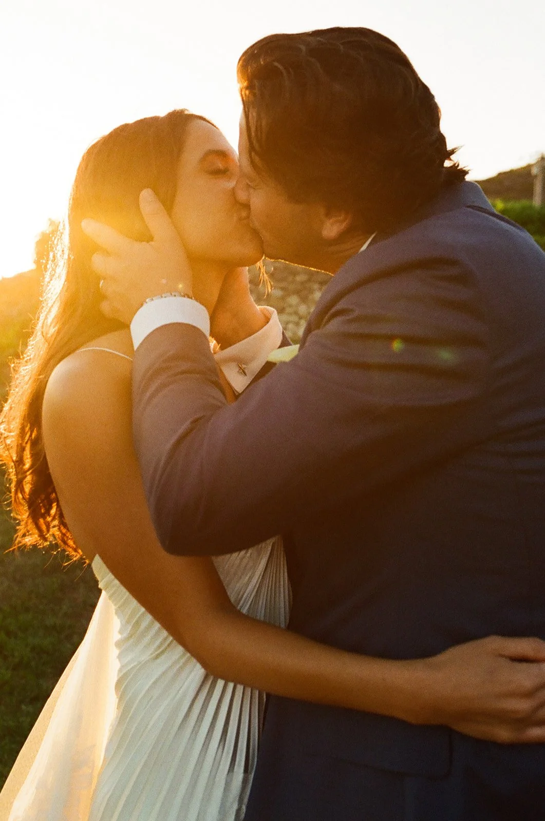 A bride and groom posing for sunset wedding photos