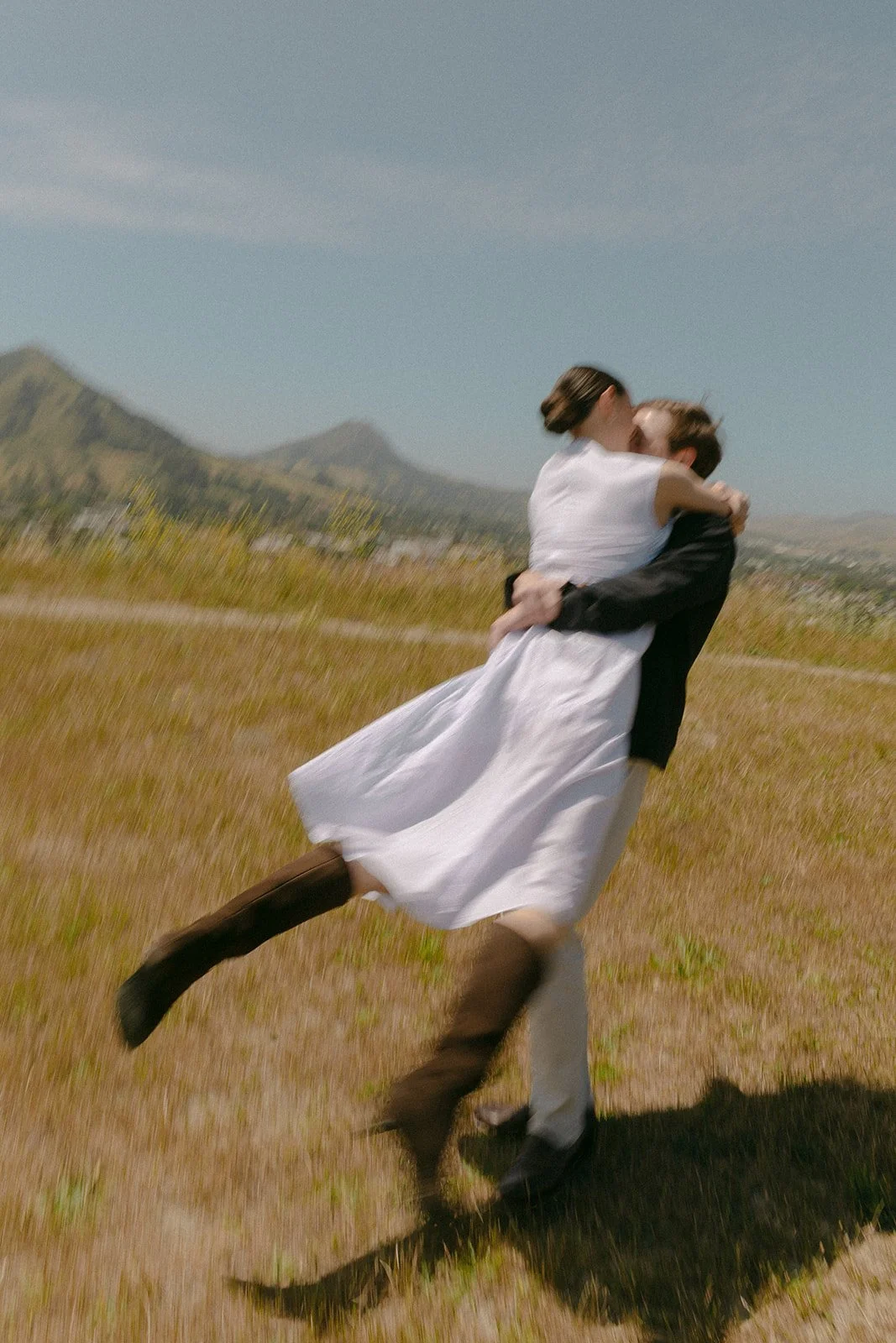 A couple spinning in field engagement photos