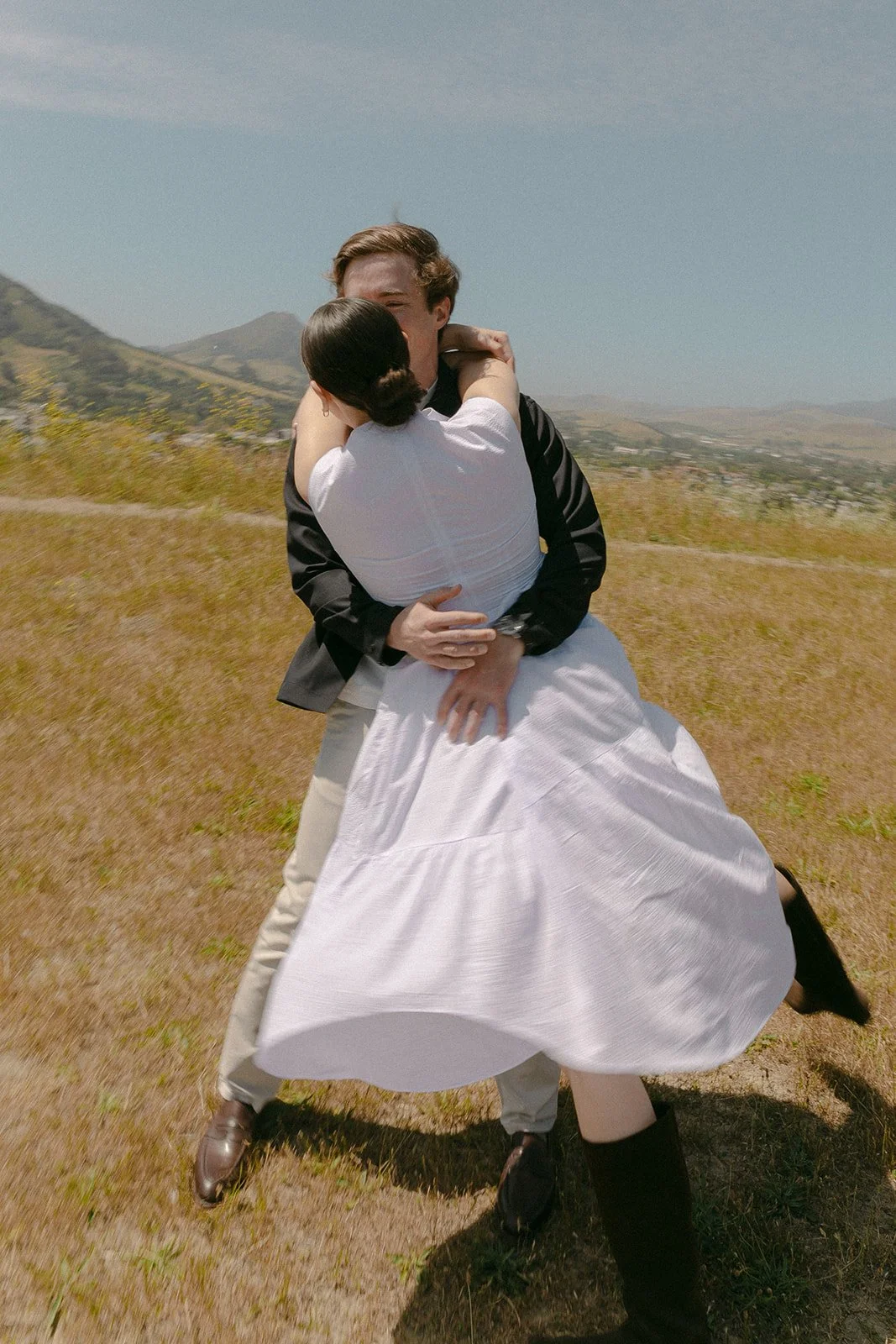 A couple spinning in field engagement photos