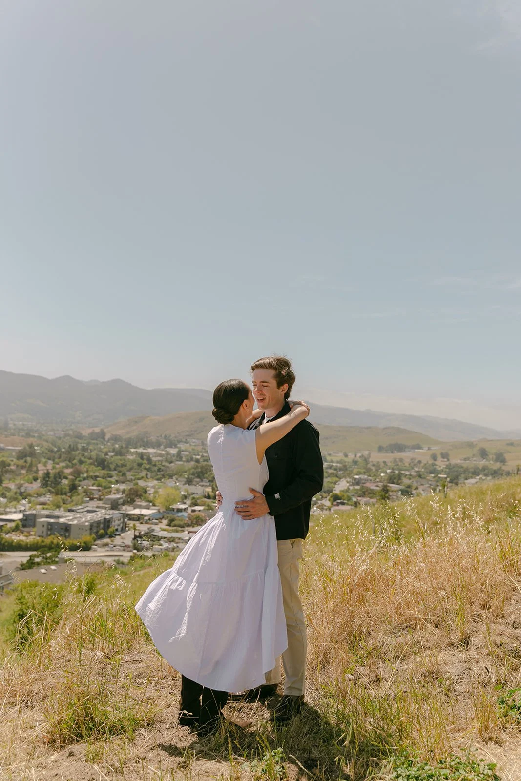 A couple posing for San Luis Obispo engagement photos on Terrace Hill