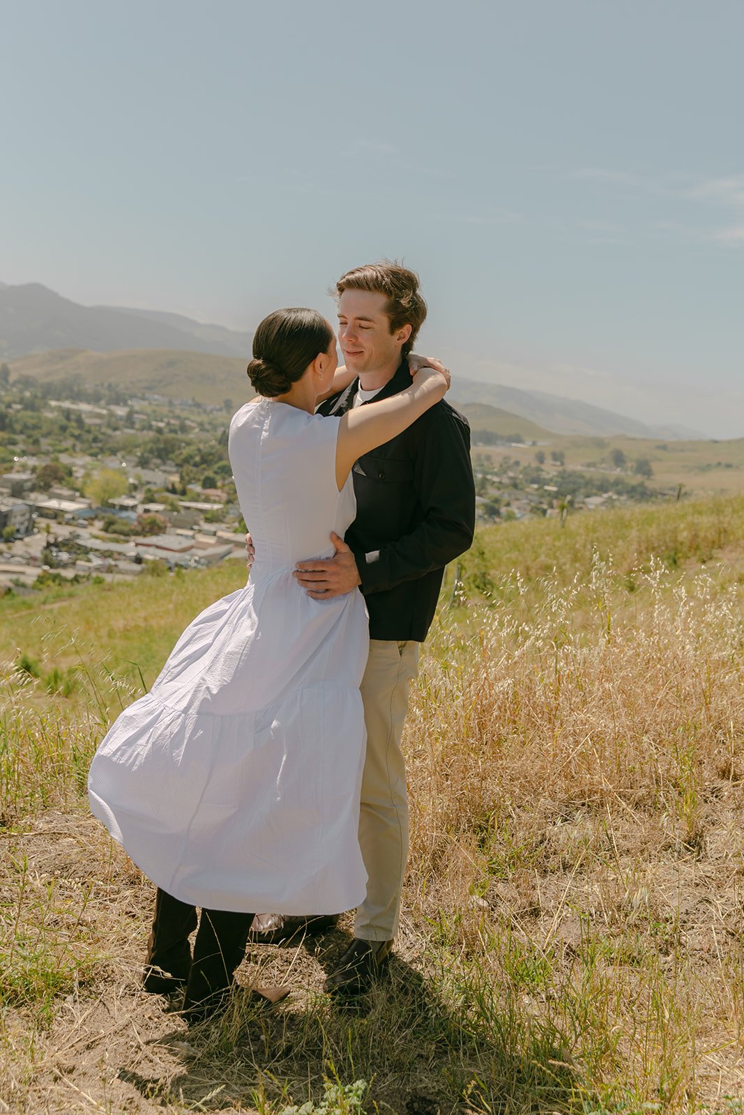 A couple posing for San Luis Obispo engagement photos on Terrace Hill