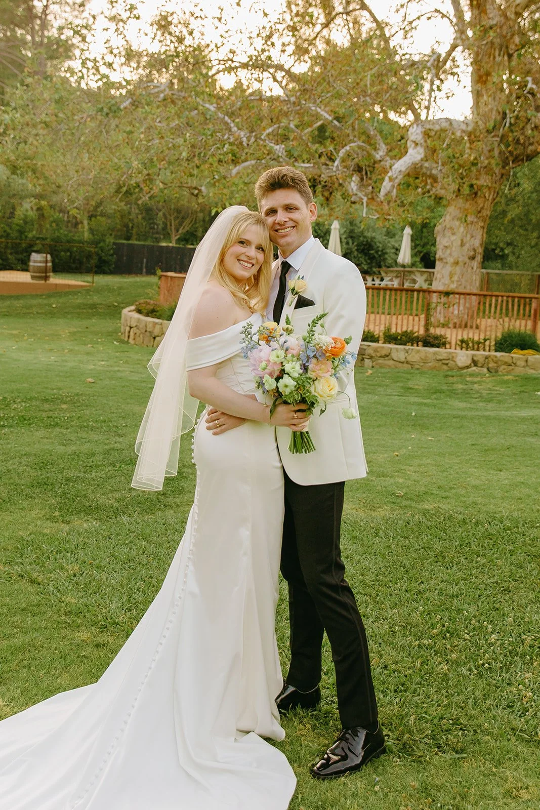 A bride and groom taking portraits on a lawn