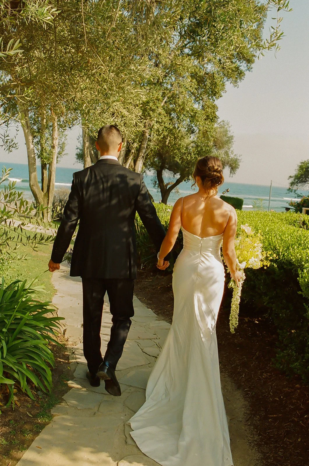 A bride and groom walking through their wedding venue, Adamson House