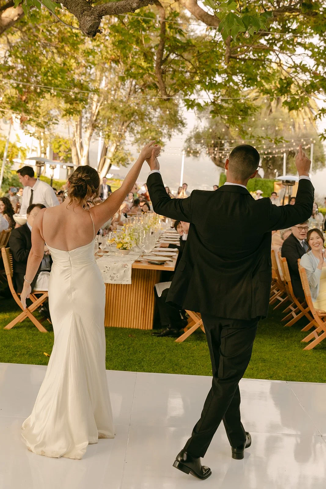 A bride and groom entering their reception