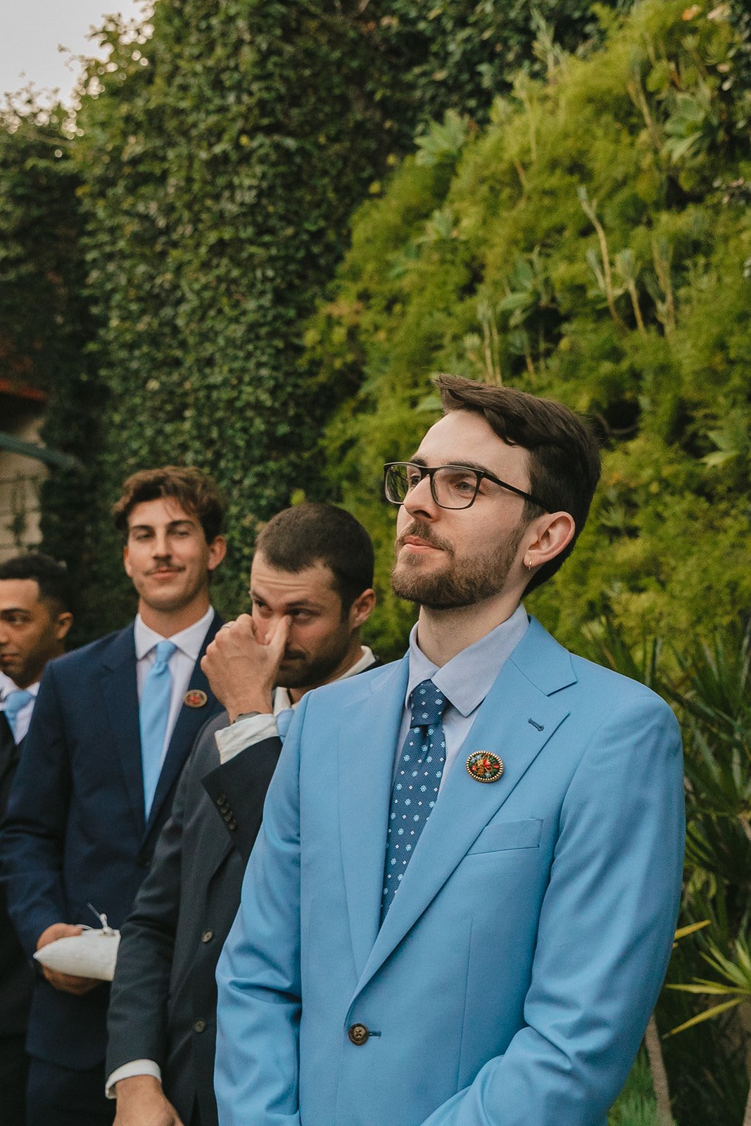 A groom watching a bride walk down the aisle