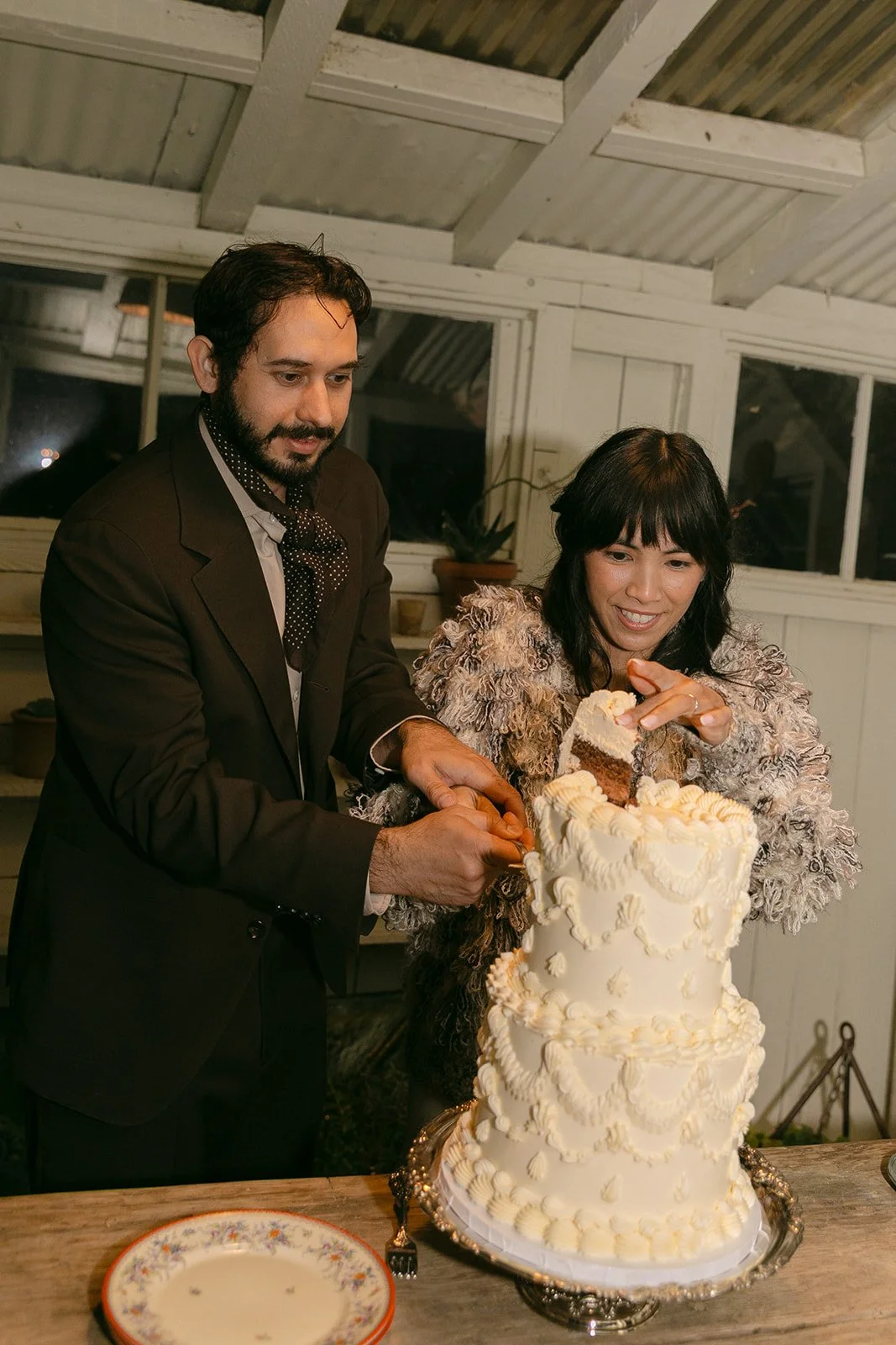 A bride and groom cutting their wedding cake