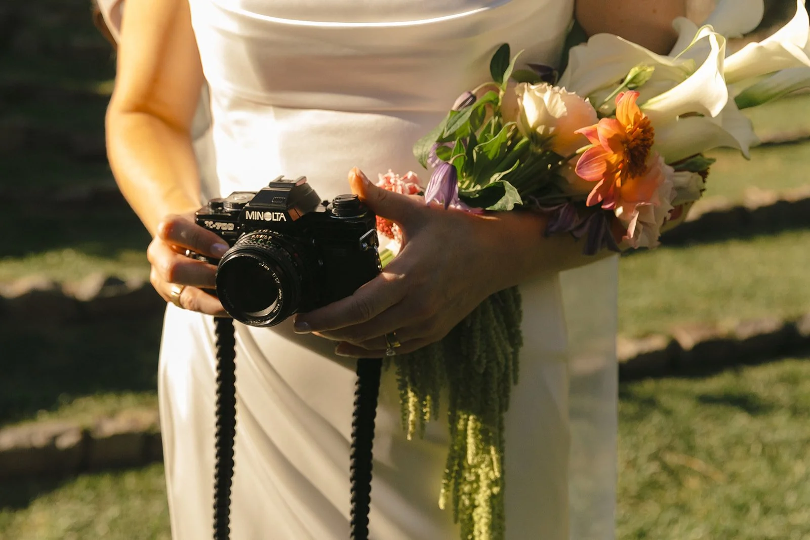 A bride holding her dad's camera as memorial ideas for weddings